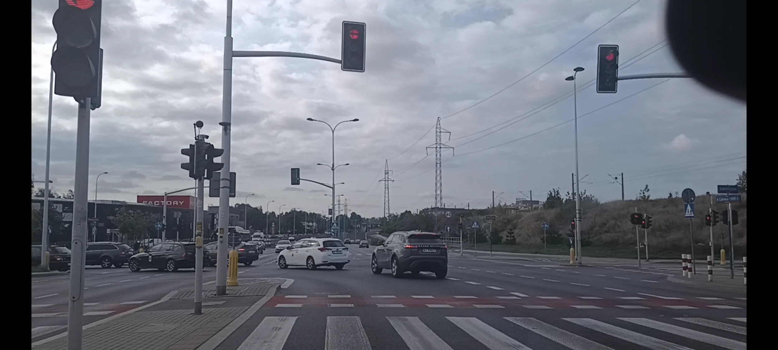 Bandyta drogowy przejeżdża przez skrzyżowanie na czerwonym sygnalizatorze świetlnym