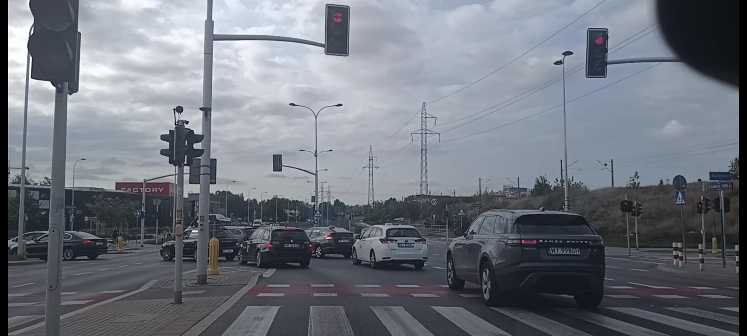 Bandyta drogowy przejeżdża przez skrzyżowanie na czerwonym sygnalizatorze świetlnym