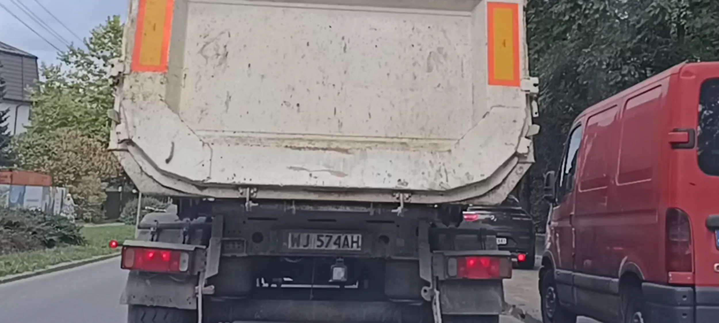 Pacan drogowy stanął pod budową pod prąd i na trawniku blokując jazdę ulicą.