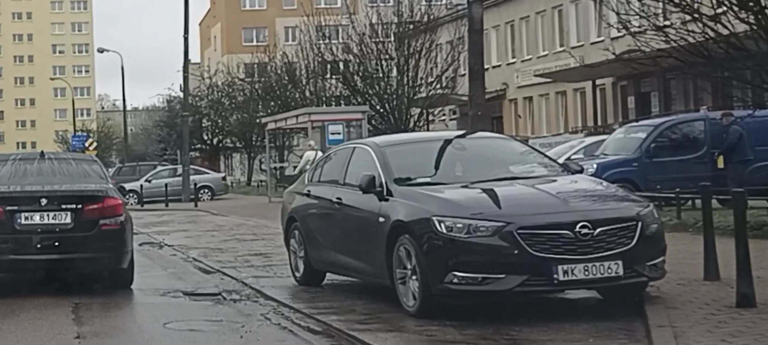 Uszkodzone auto po wypadku stoi porzucone w zatoce przystanku autobusowego.