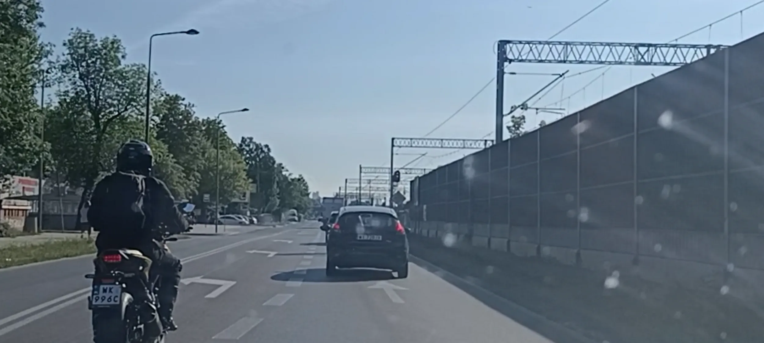 Bandyta na motocyklu wyprzedza z prędkością 90 kmh w miejscu ograniczenia prędkości do 50 kmh, jedzie prosto pasem do skrętu w lewo, jedzie po pasach wyznaczających miejsce na jezdni wyłączone z ruchu. Kryminał i bandytyzm drogowy po prostu.