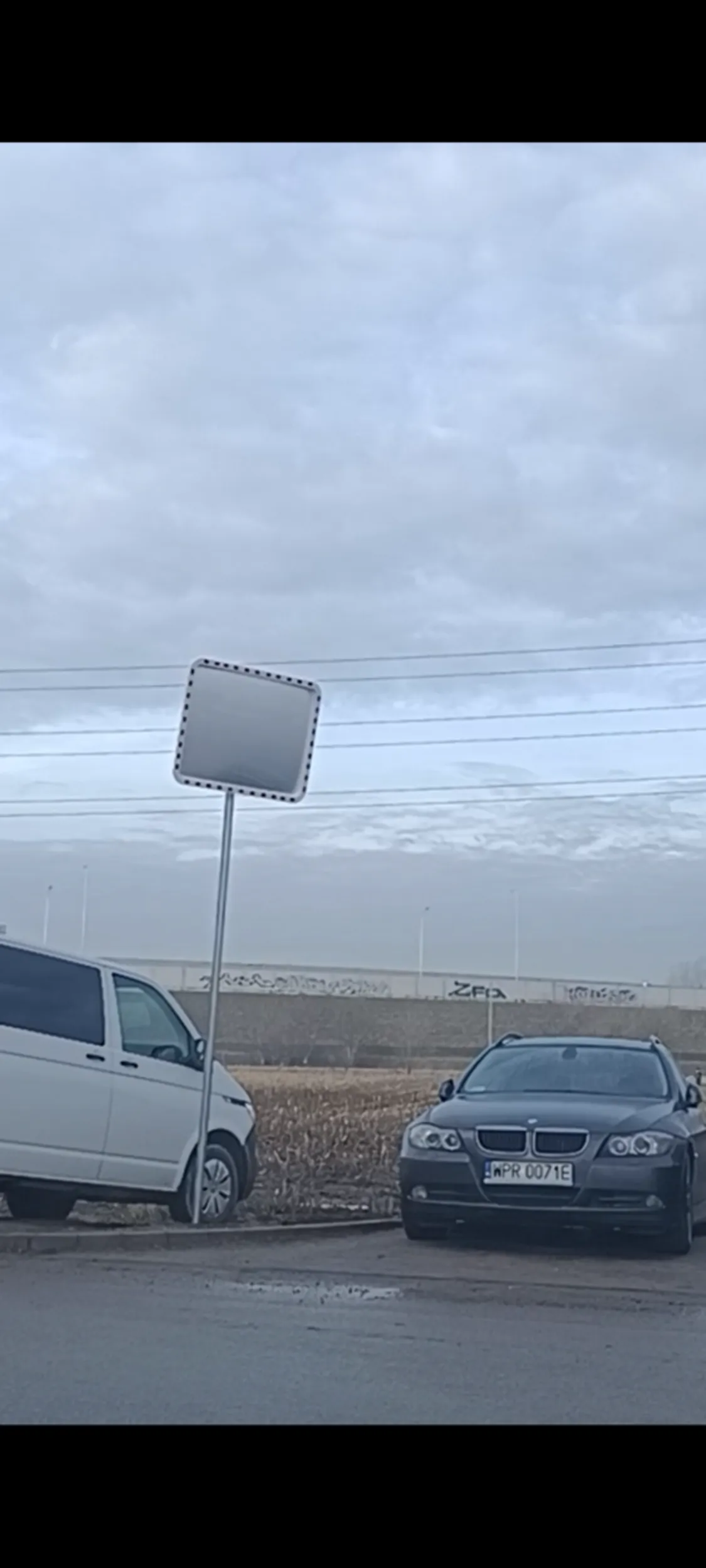 Złomiarz trzyma złoma BMW w miejscu gdzie nie ma miejsca parkingowego.