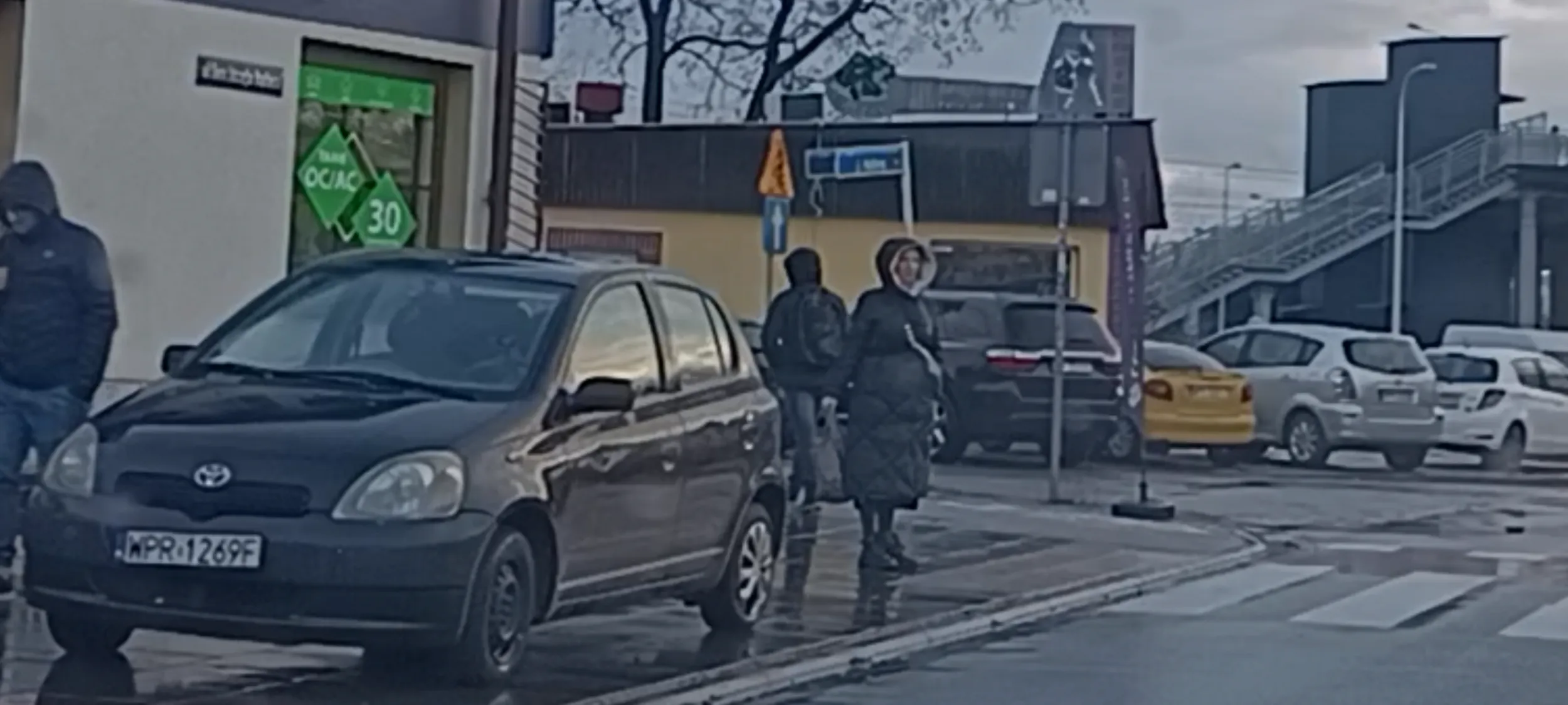 Auto ze śladami wypadku stoi przed przejściem dla pieszych w miejscu nie dozwolonym, 2m od przejścia