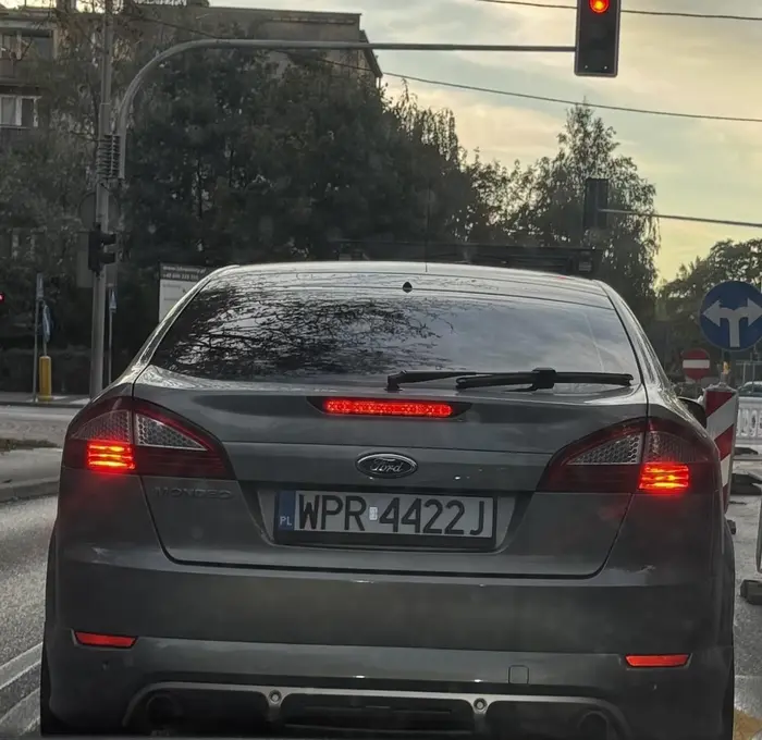 Wymusza pierwszeństwo. Hamuje przed maską oraz wjeżdża pod zakaz widoczny na wprost na zdjęciu. Prawko do zabrania