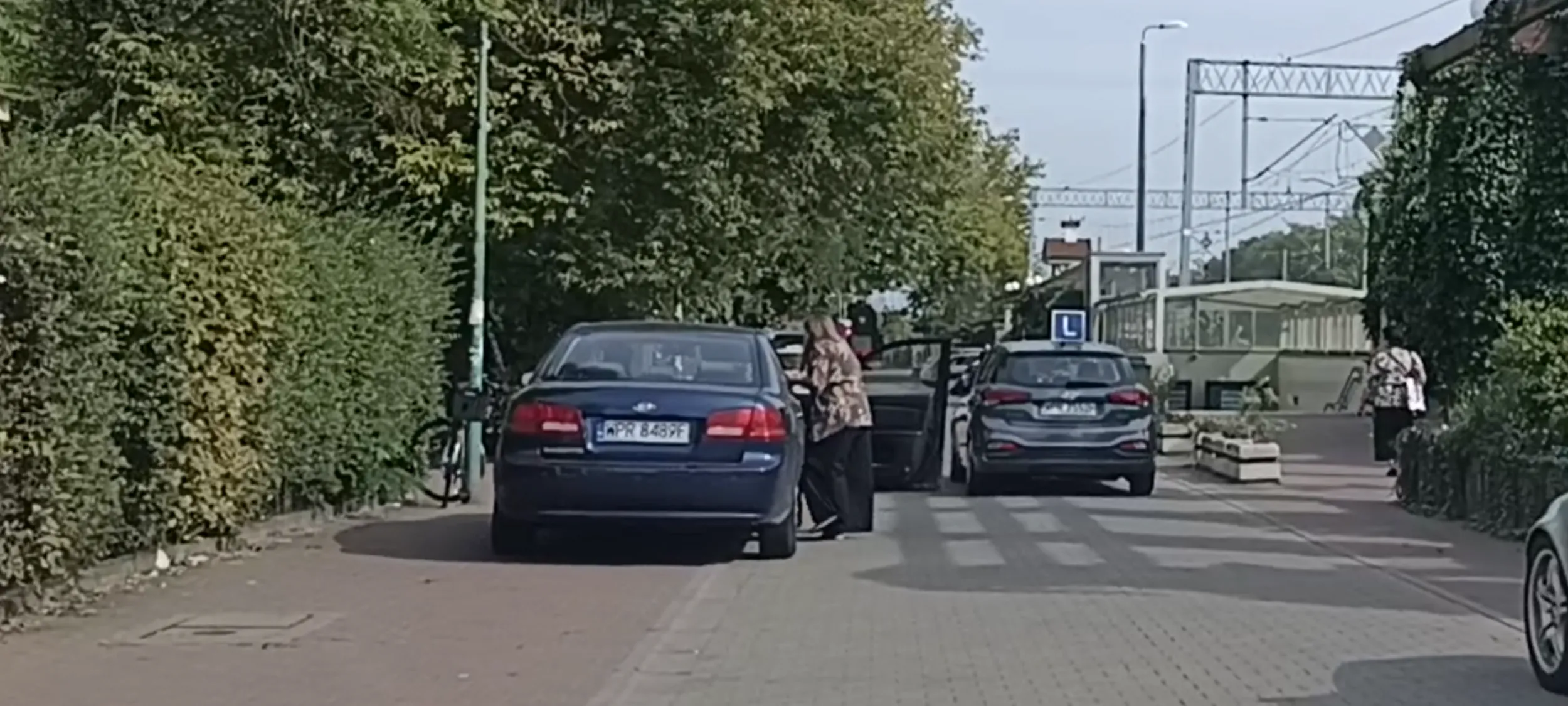 Babszczur z patokierowcą stoi na zakazie zatrzymywania się i postoju i blokuje przejazd zardzewiałymi drzwiami ze śladami po wypadku drogowym.