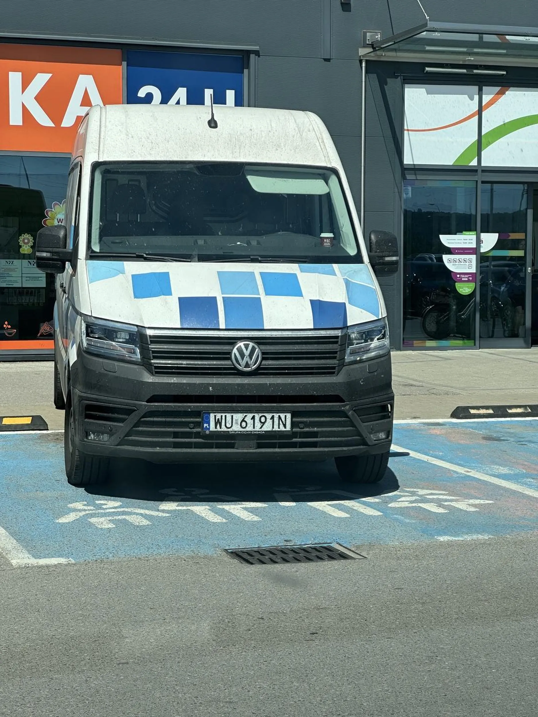 Młody, zdrowy chłopak parkuje autem dostawczym na miejscu dla rodzin z małymi dziećmi i kobiet w ciąży. Zupełnie bez wyobraźni, takie miejsca specjalnie są przed wejściami, żeby osoby, które takich miejsc potrzebują mogły z nich skorzystać.