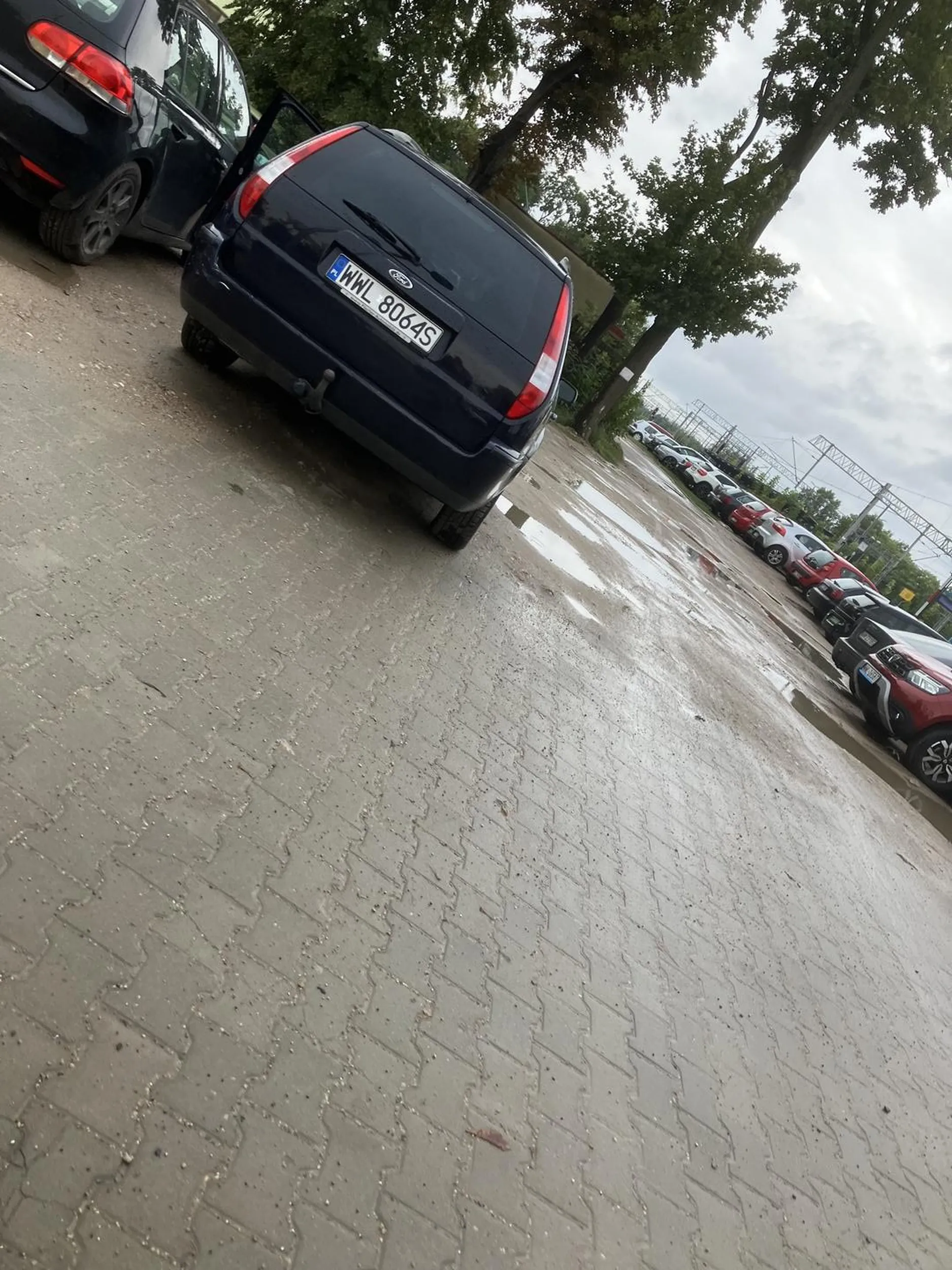 Blokuje połowę wjazdu na parking, a drzwiami obija inne samochody.