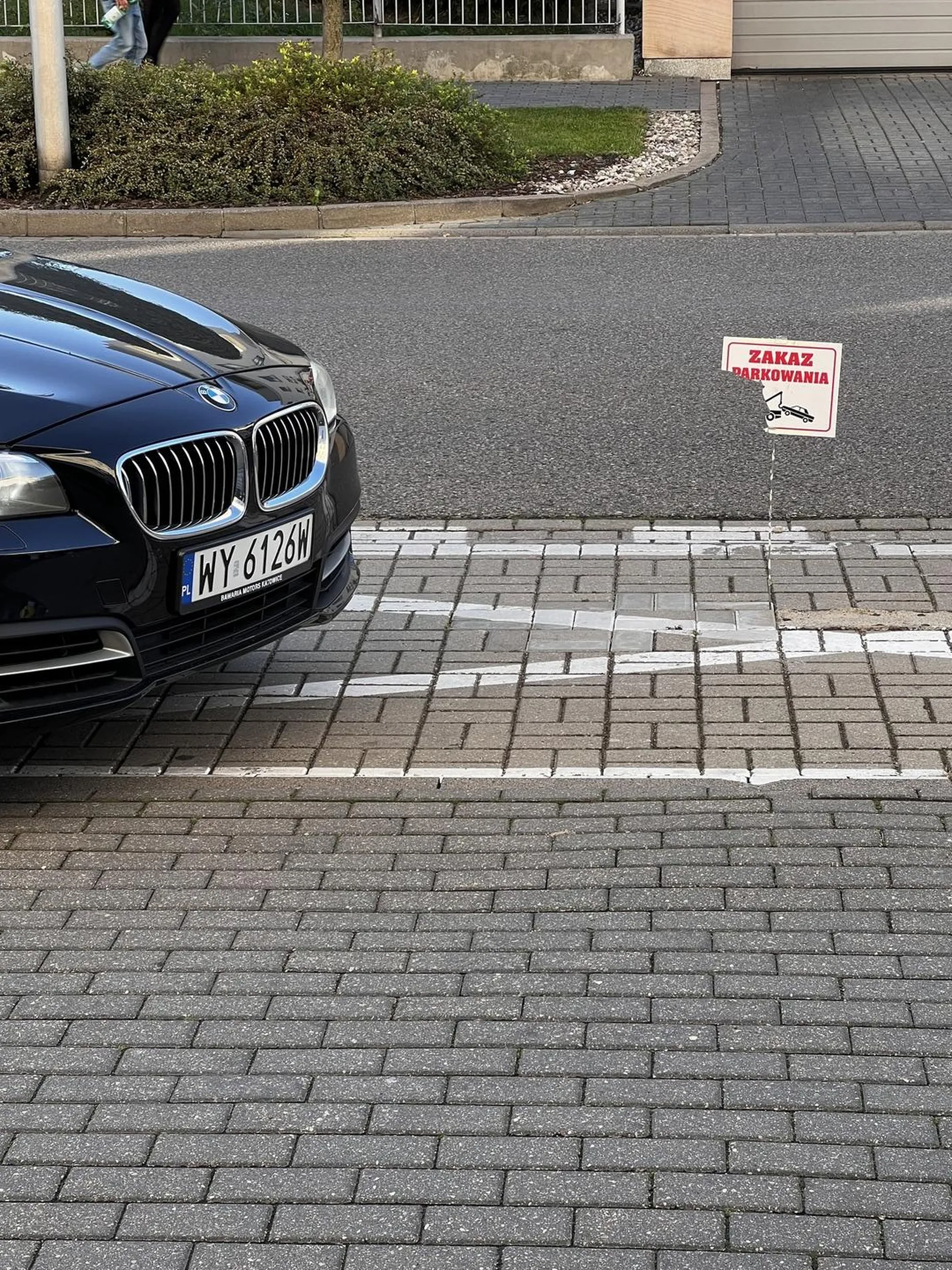 Kierowca nie zwraca uwagi na znaki drogowe. Zajmuje prywatne miejsce postojowe.