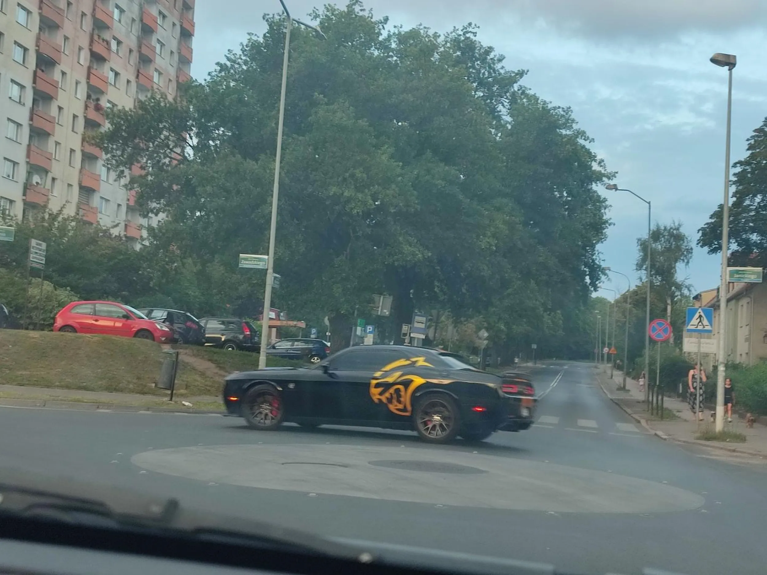 Dodge Challenger SRT Hellcat Czarny ze złotymi akcentami w postaci pasów na karoserii i dwóch złotych Hellcatów po jednym na lewym i prawym boku.