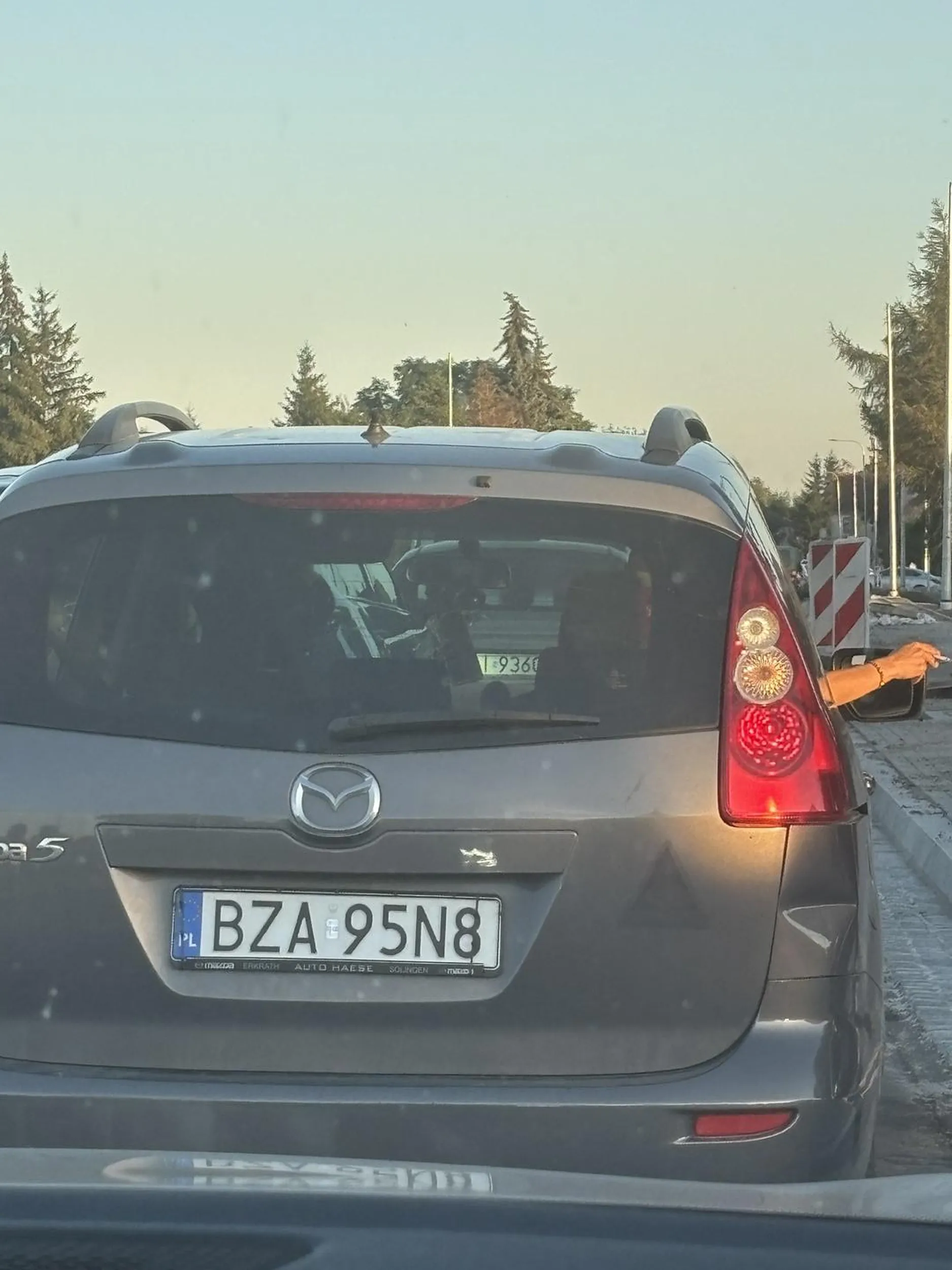 Dwa przyglupy palą w samochodzie z dziećmi