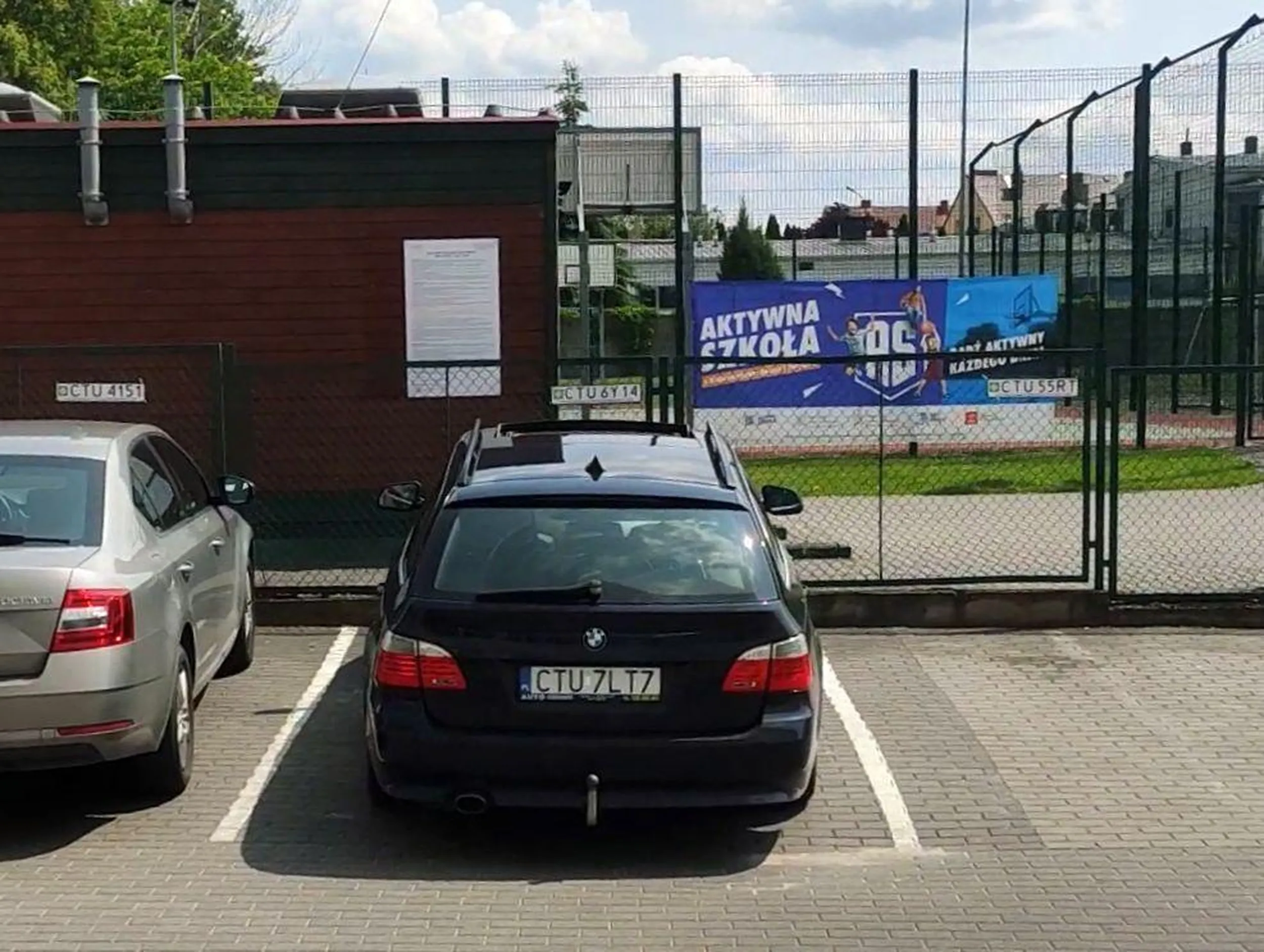 Ktoś zajmuje nieswoje miejsce. Na płocie wiszą tabliczki z nr rej.