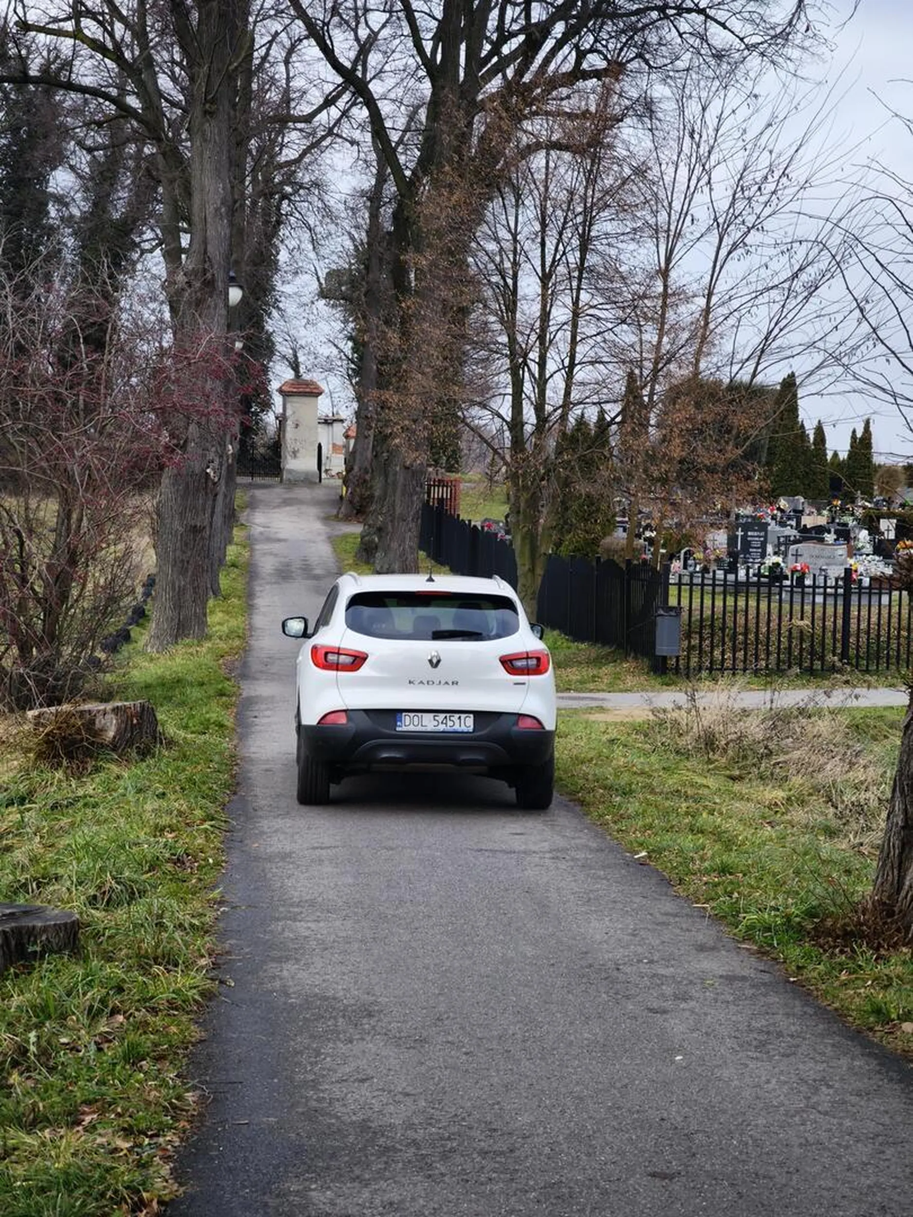 Cham jeździ po chodniku prowadzącym do cmentarza Na początku stoi znak zakaz wjazdu