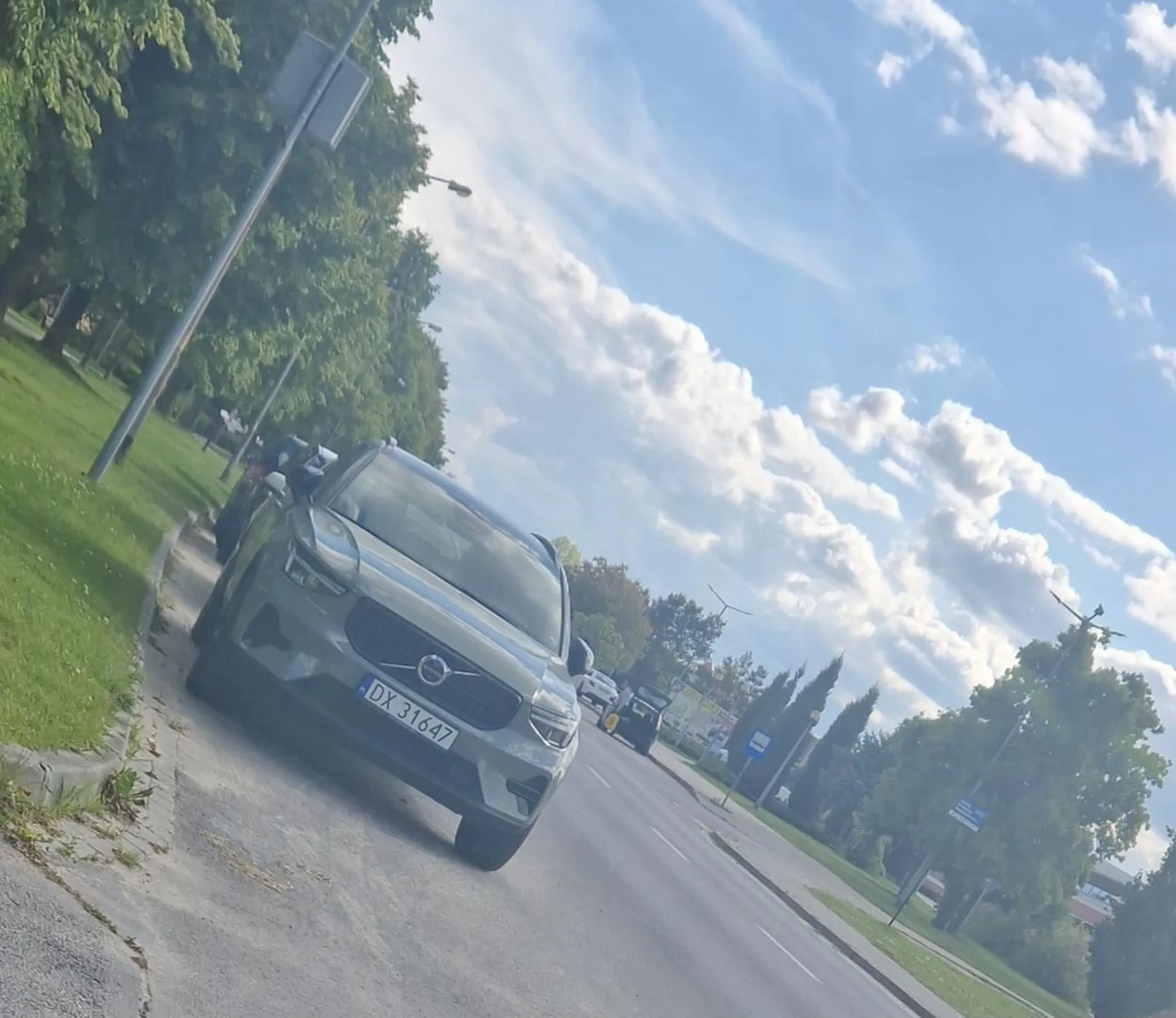 Stoi poza strefa do parkowania i zaslania nadjeżdzajace auta.