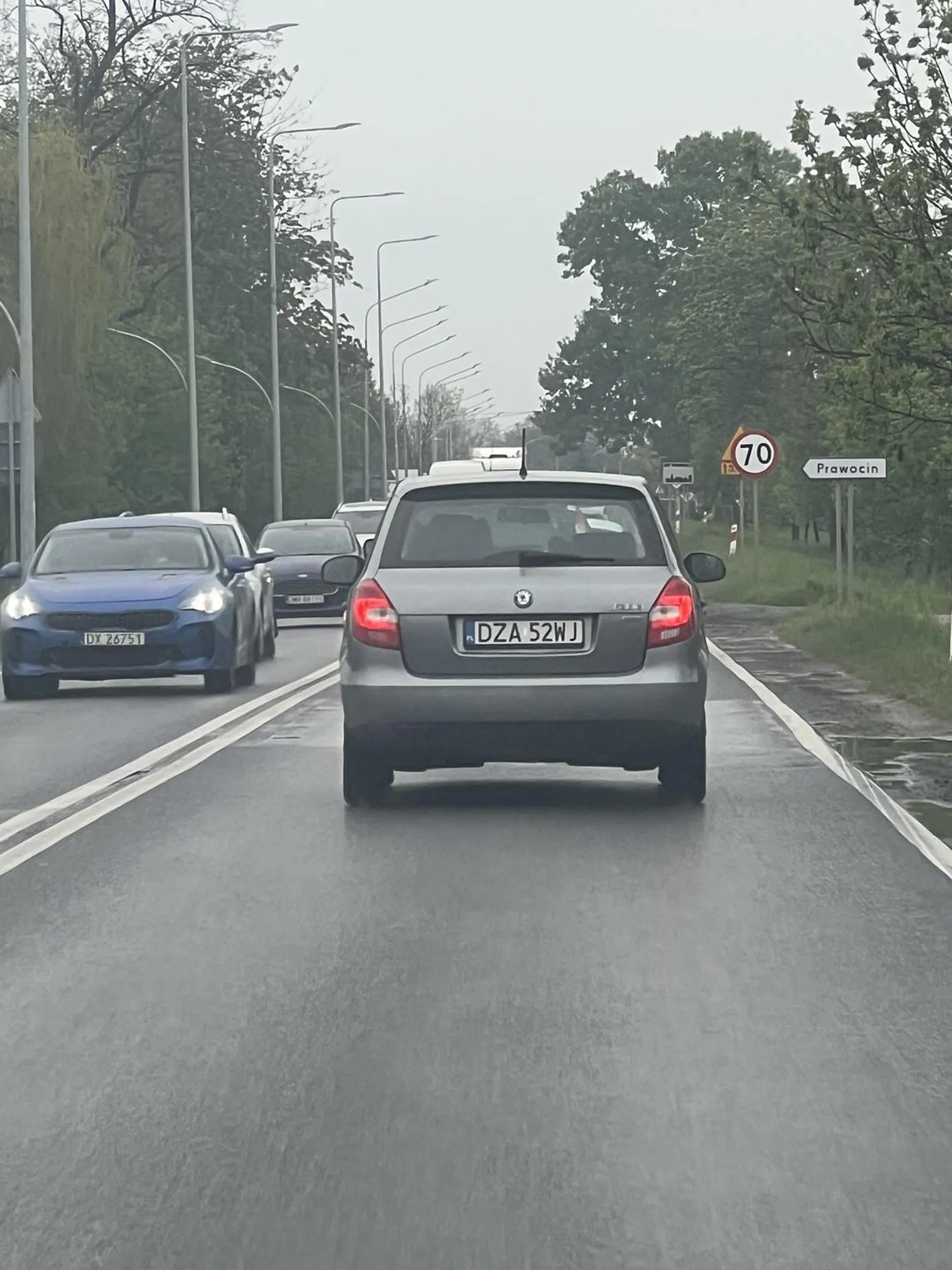 Baba z telefonem w rece nie uzywajaca kierunkowskazów na ruchliwej krzyżówce.