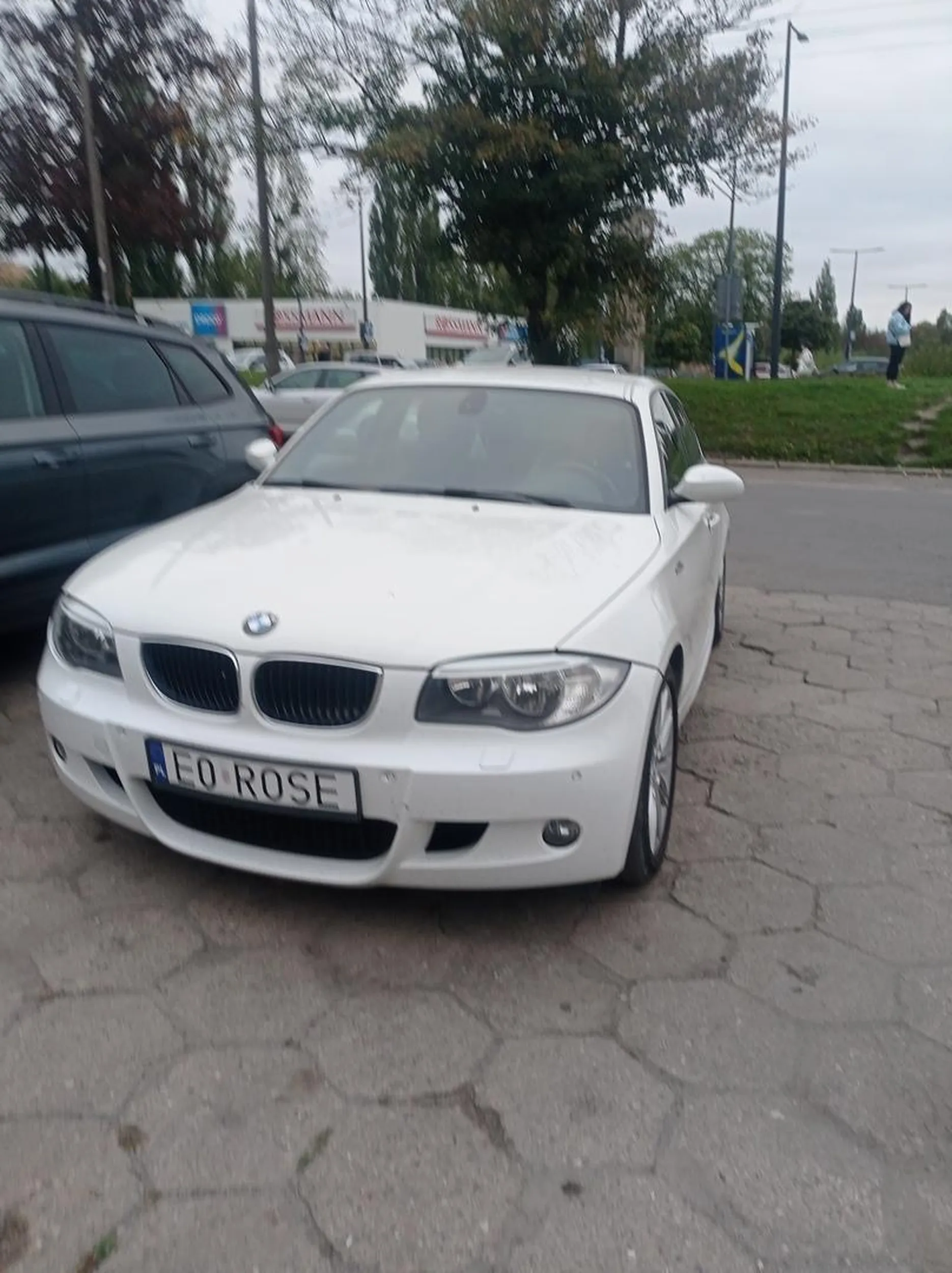 Burak z białego BMW nie umie parkować i staje na zakazie pod bramą