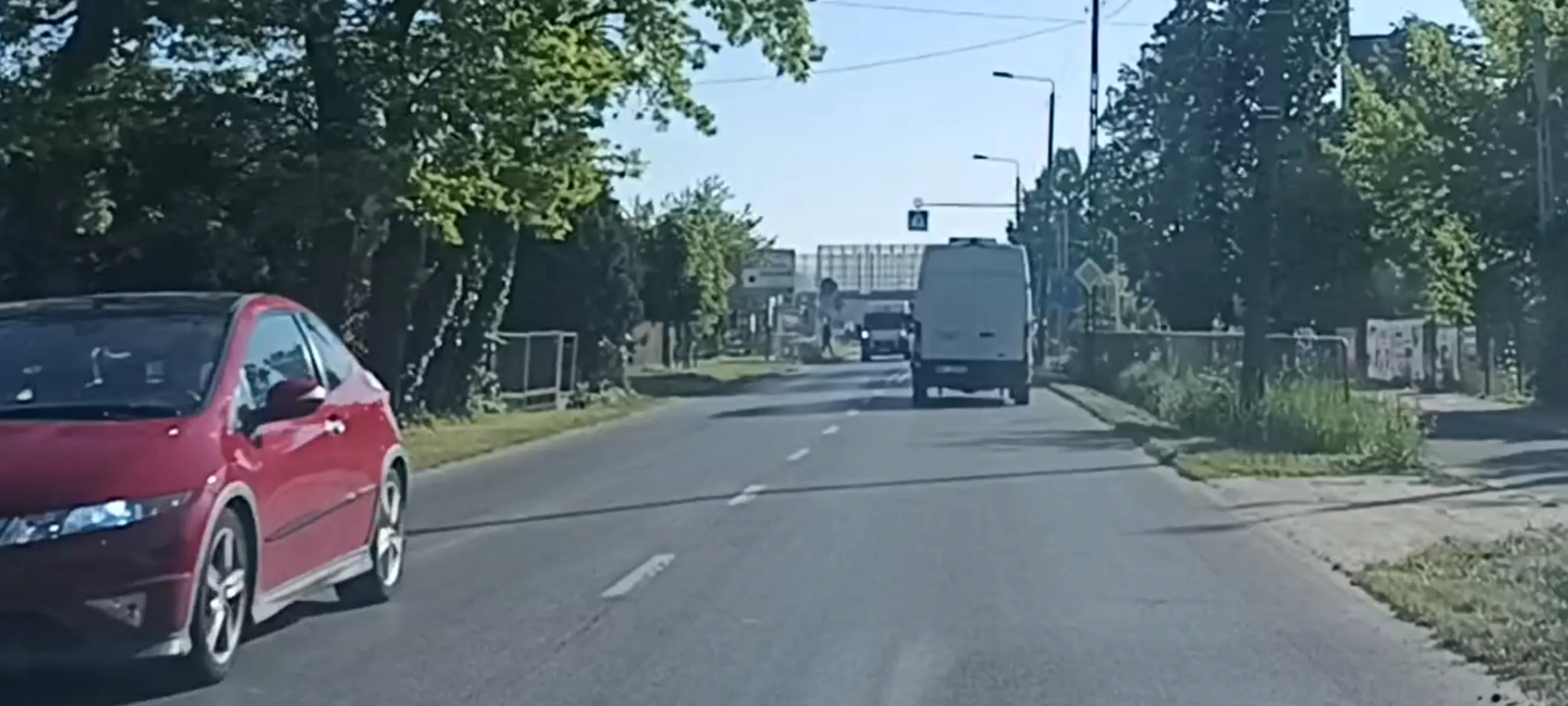 Bandyta drogowy przejeżdża przez przejście dla pieszych tuż przed ojcem z dzieckiem wchodzącym na przejście.