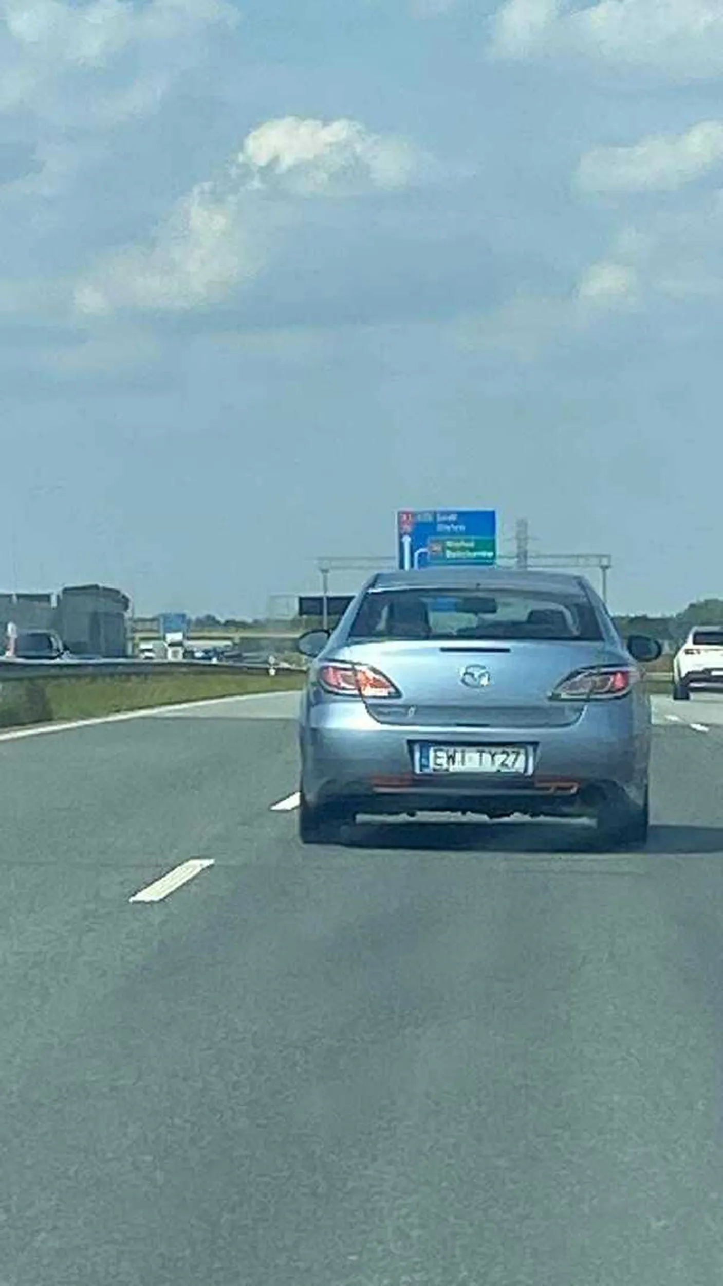 wyrzuca śmieci przez szybę, podczas jazdy na autostradzie