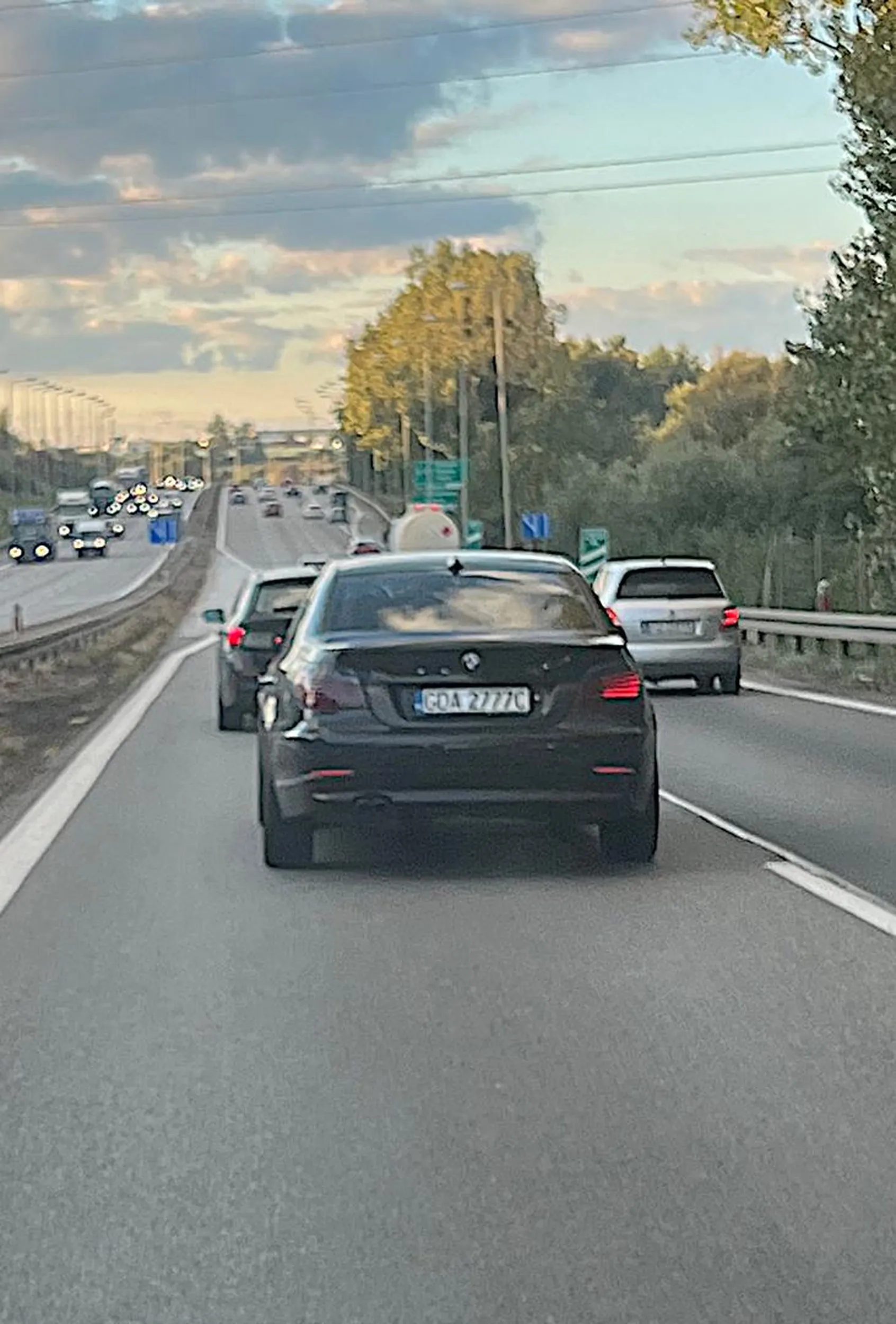 Pirat drogowy! Robi niebezpieczne manewry, znacznie przekracza dozwoloną prędkość, jeździ z telefonem w ręku (prawdopodobnie streamuje jazdę) i zajeżdża drogę. Jeździ BMW E60 w kolorze czarnym.