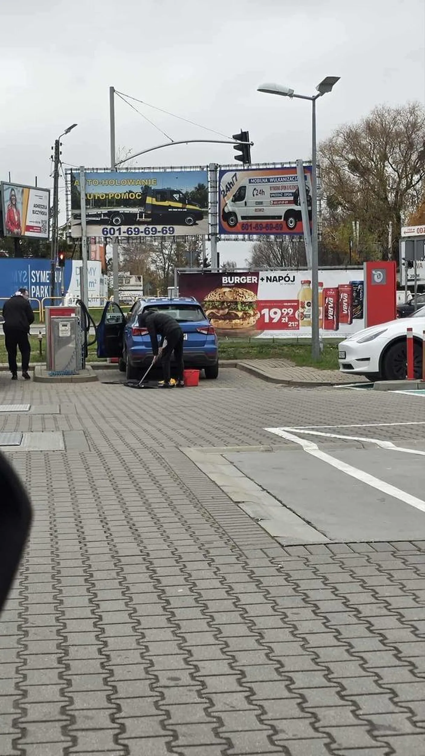 Wsiuny myją wycieraczki szczotką do szyb ze stacji