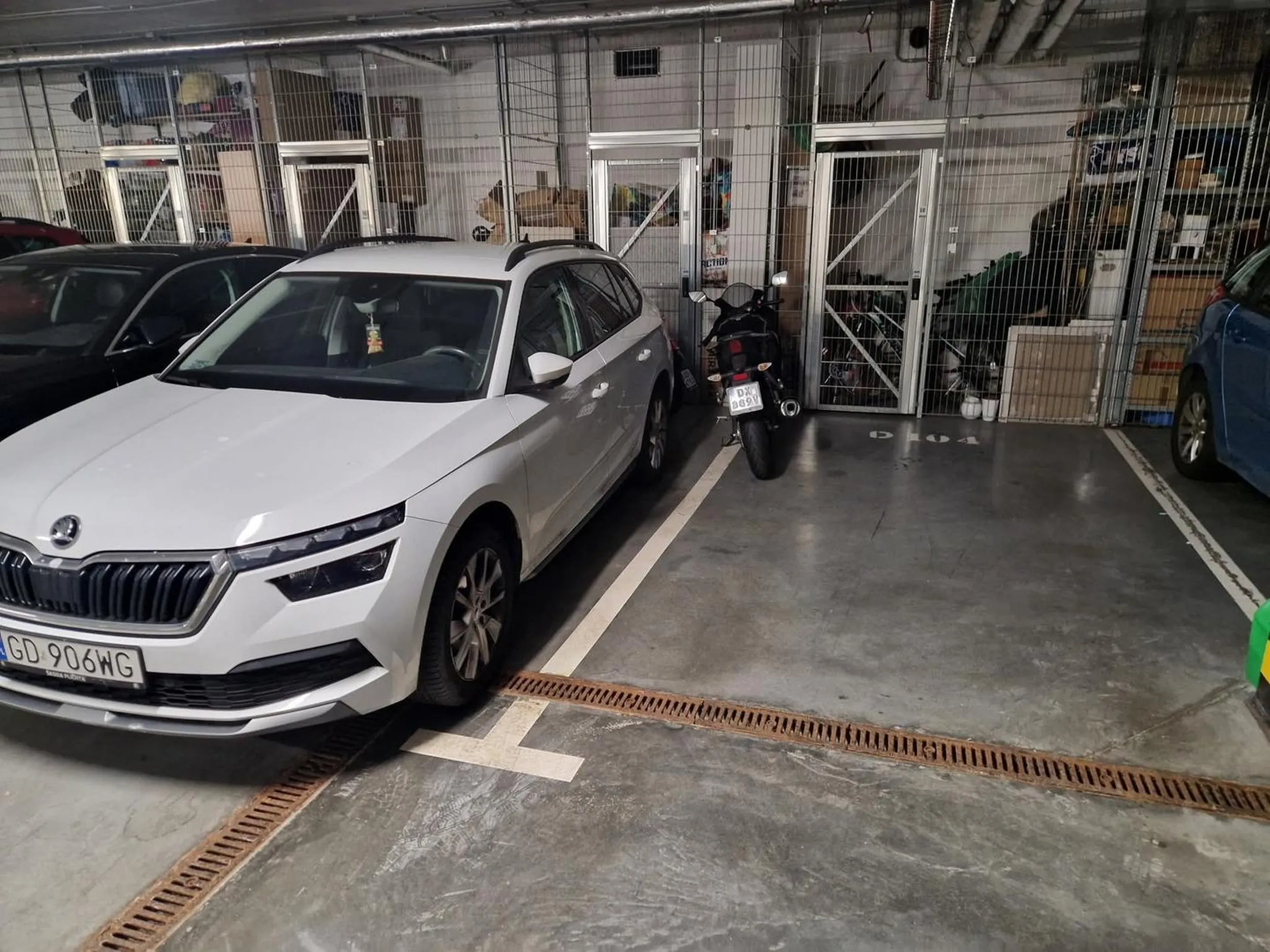 Janusz parkuje swojego gruchota motórka nie na swoim miejscu na parkingu osiedlowym