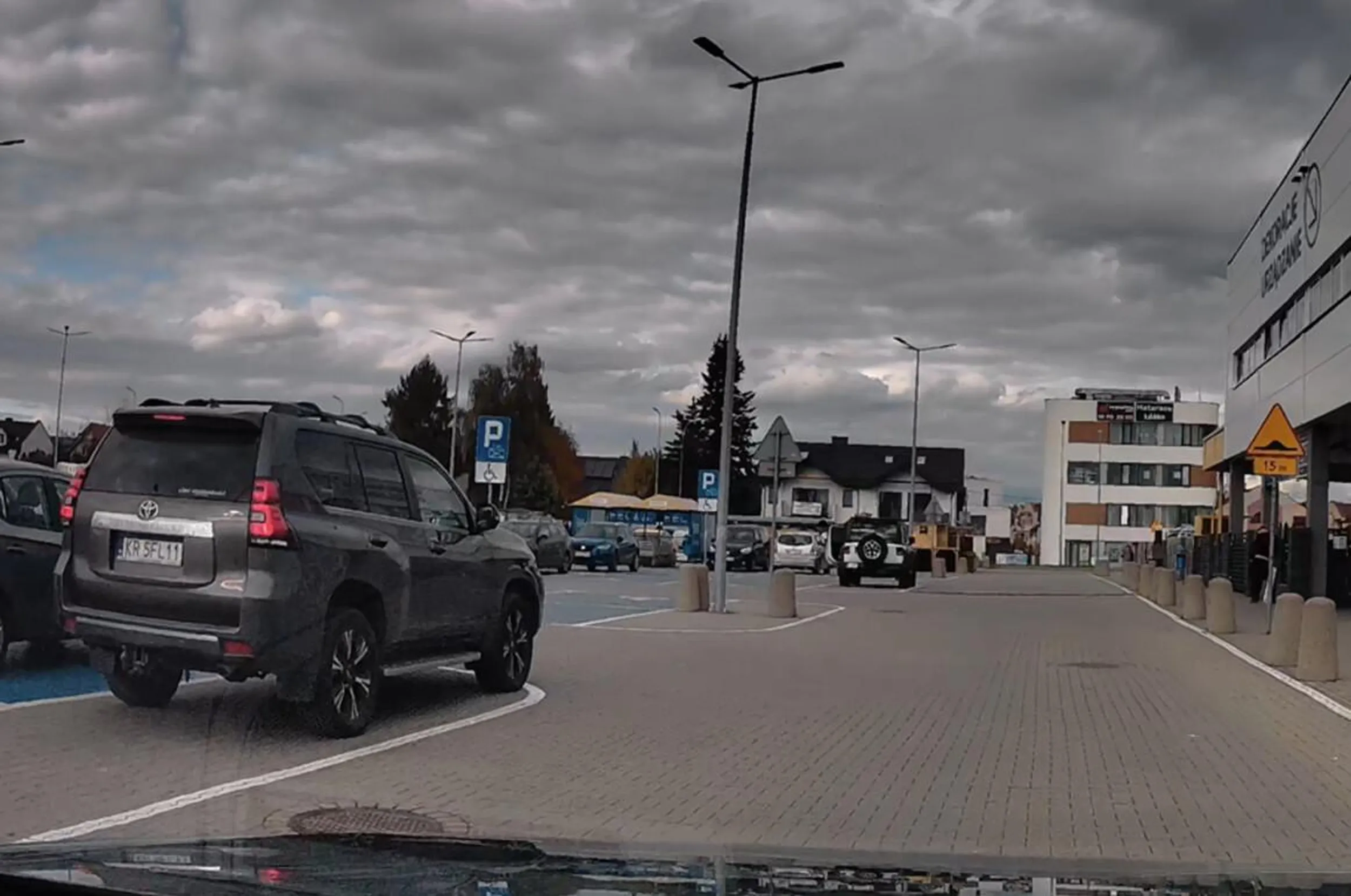 ciele parkuje utrudniając widoczność, a pół parkingu wolnego