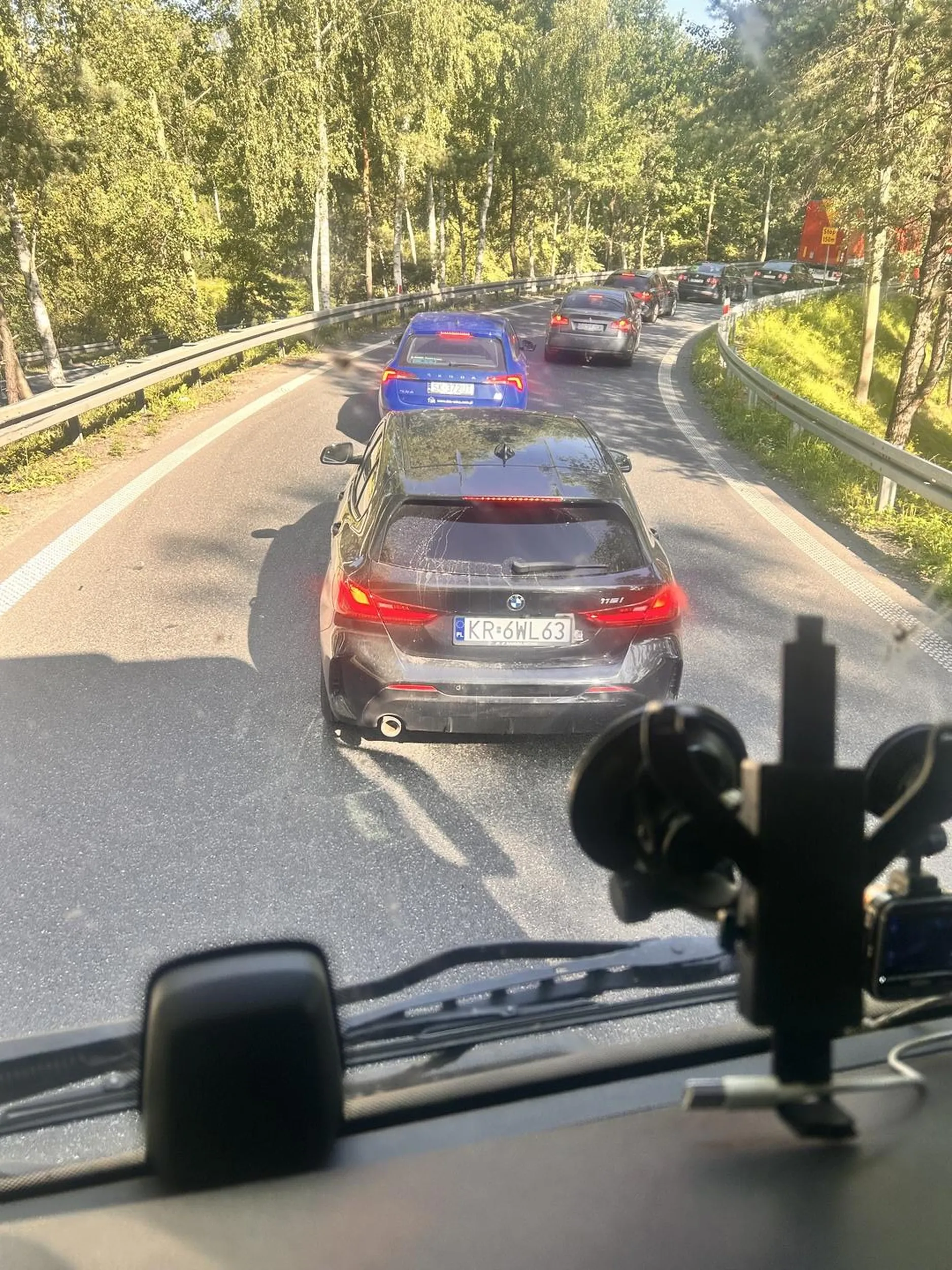 Kierowca BMW na siłę wymusza wciska się w zjazd w ostatniej chwili pod maskę ciężarówki