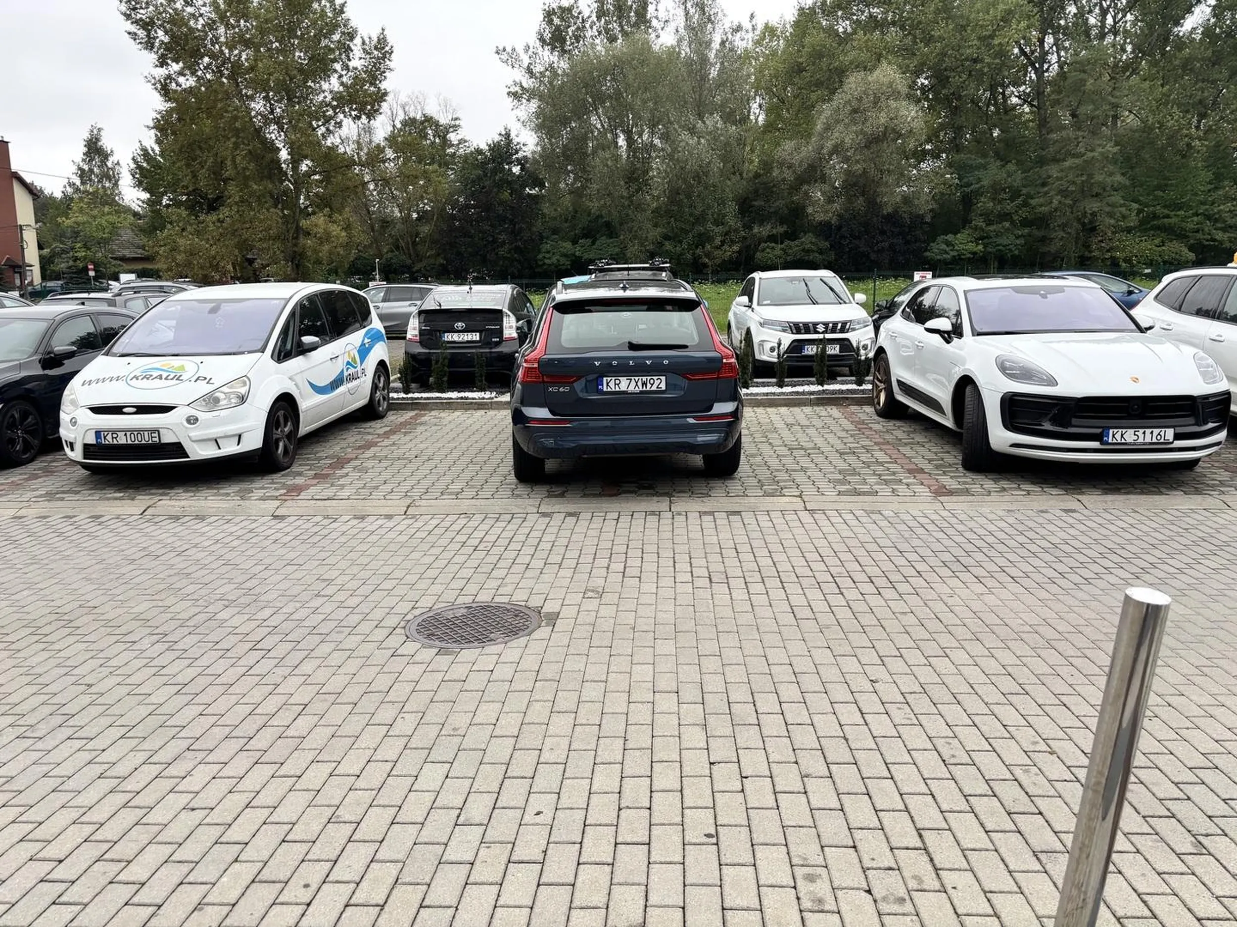 Zatłoczony parking pod centrum sportowym.