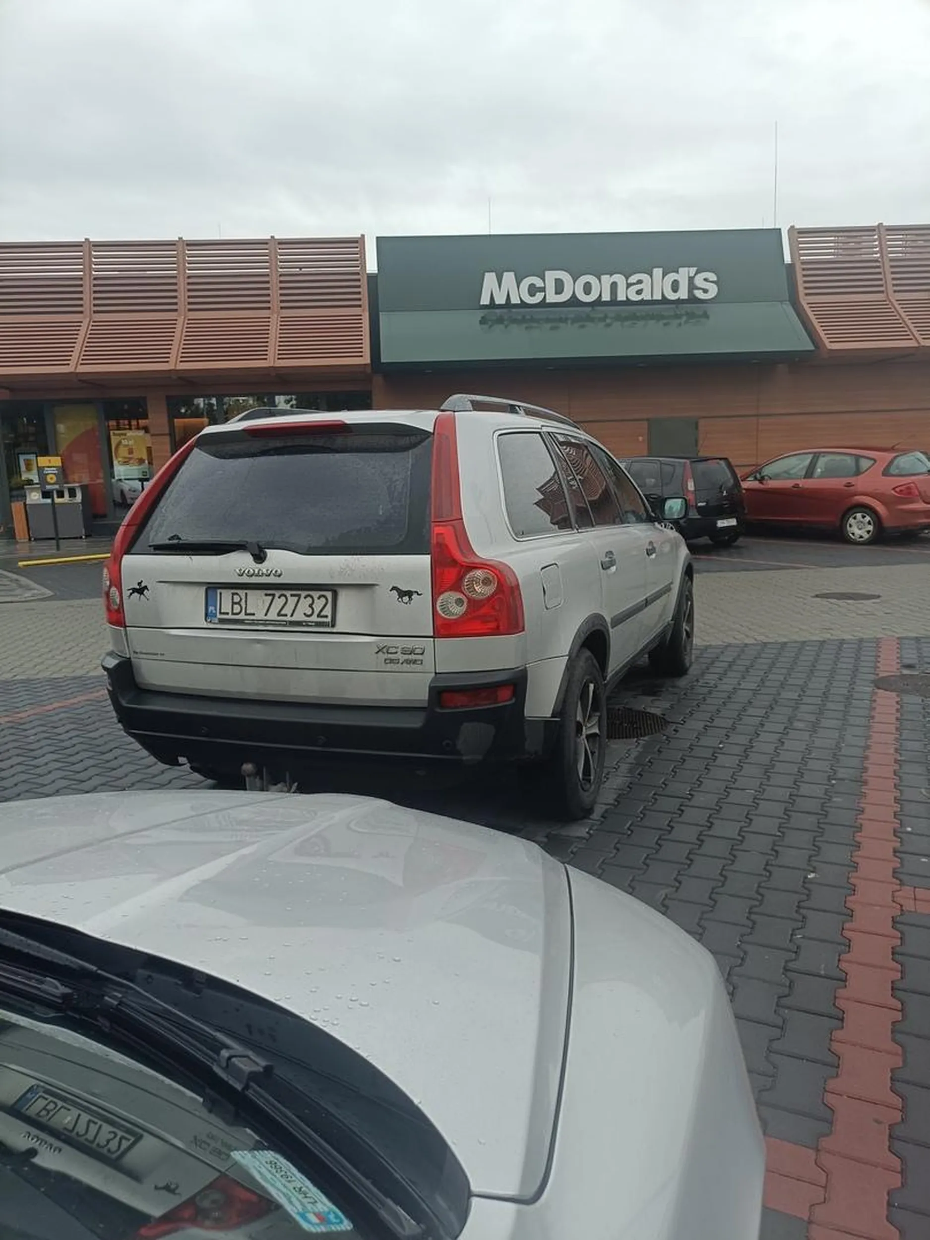 Auto zaparkowane na dwóch miejscach.