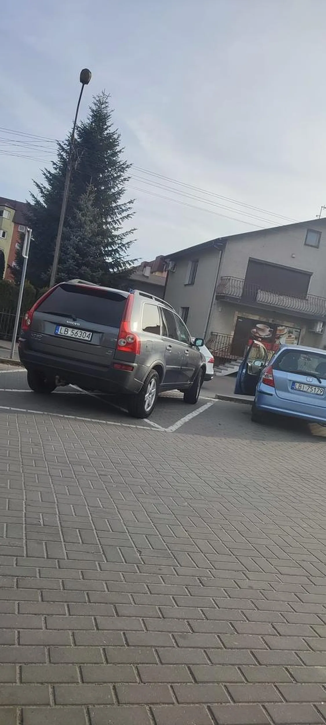 Kierujący stanął centralnie przed przejściem dla pieszych. Na parkingu było co najmniej 5 wolnych miejsc.