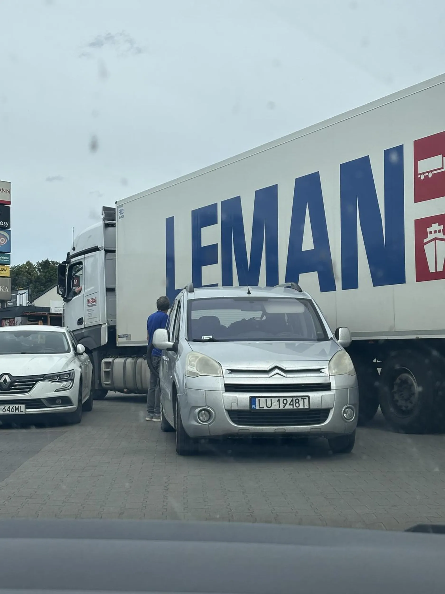 Kierowca zaparkował sobie poza parkingiem, jak gdyby nigdy nic i teraz tir z dostawą musi być kierowany przez postronnych ludzi, żeby nie zahaczyć tego inteligenta