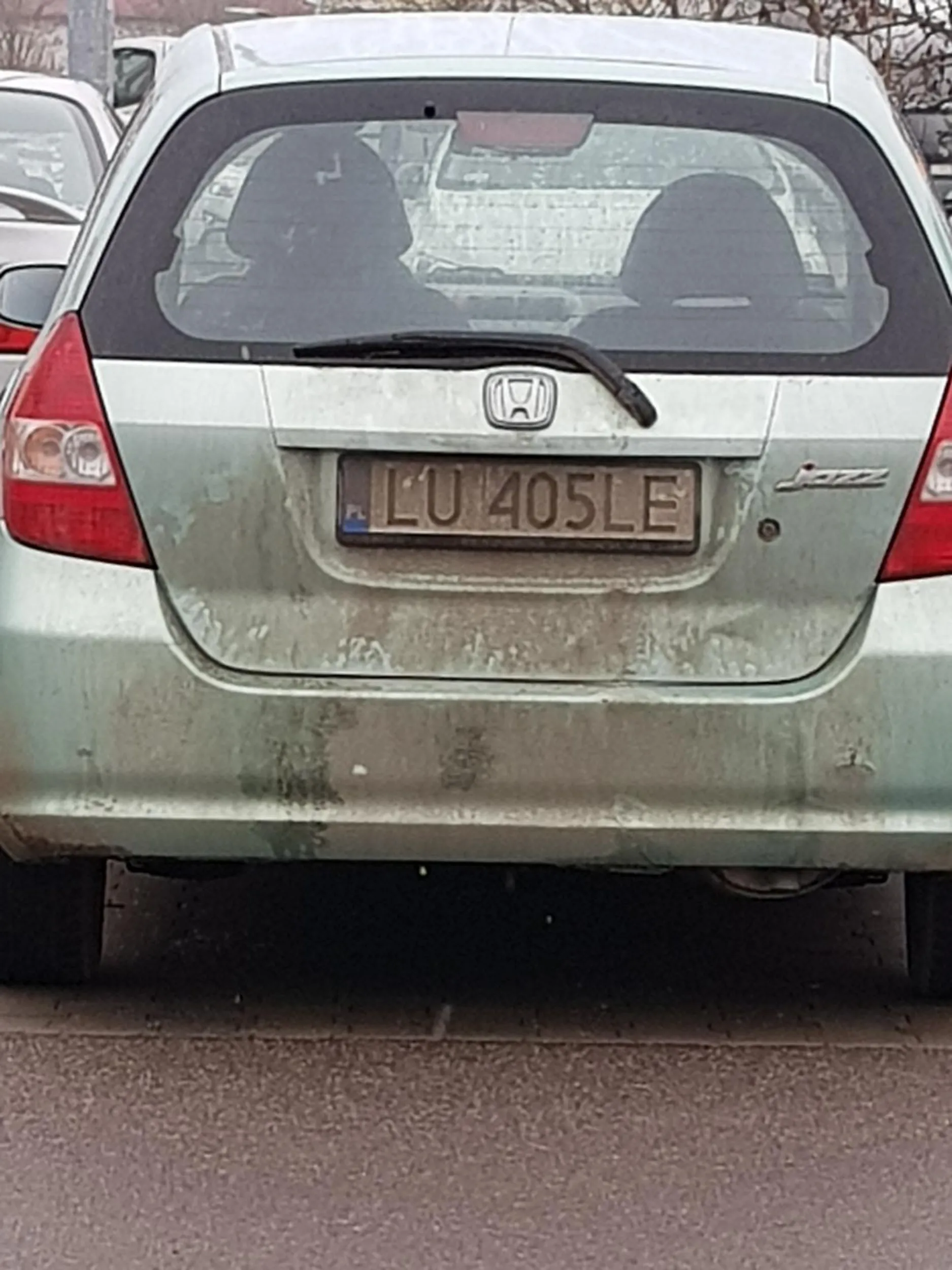 Dałn brudnym,  seledynowym gwnem przejeżdża w poprzek parking po wszystkich miejscach parkingowych z dużą prędkością.
