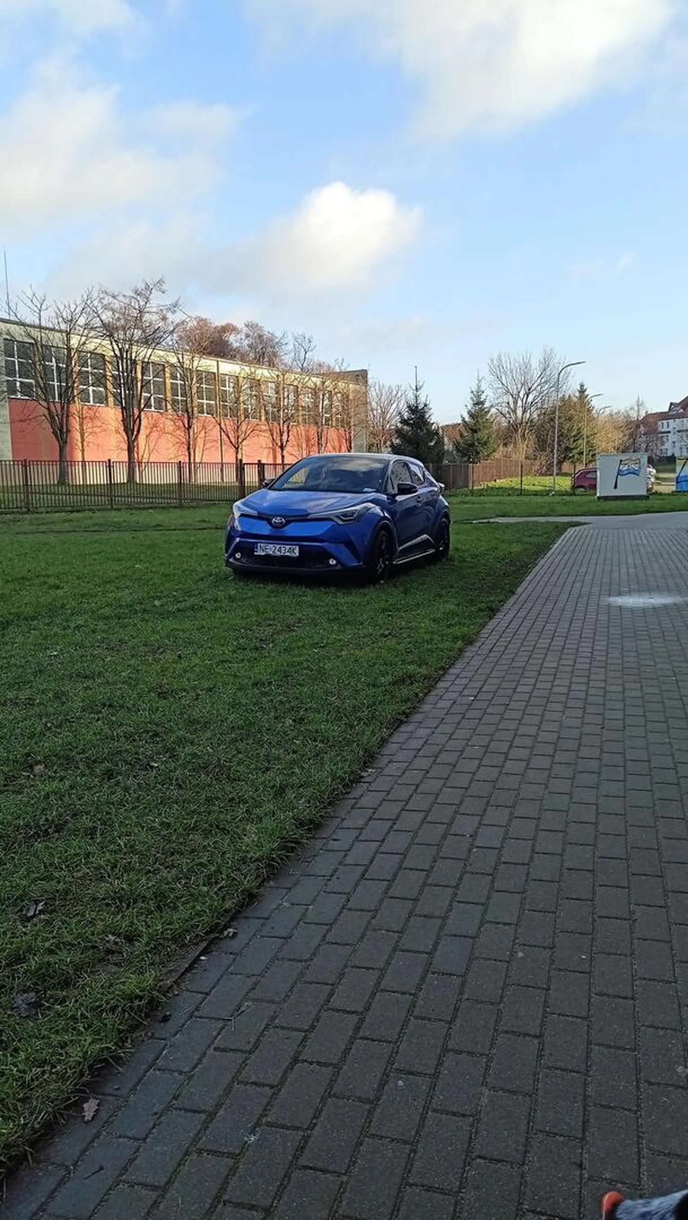 Staje na trawniku, jeździ po chodniku. Ja rozumiem, że do bloku nie ma bezpośredniego dojazdu, ale jakoś inni sobie radzą i nie niszczą trawników.