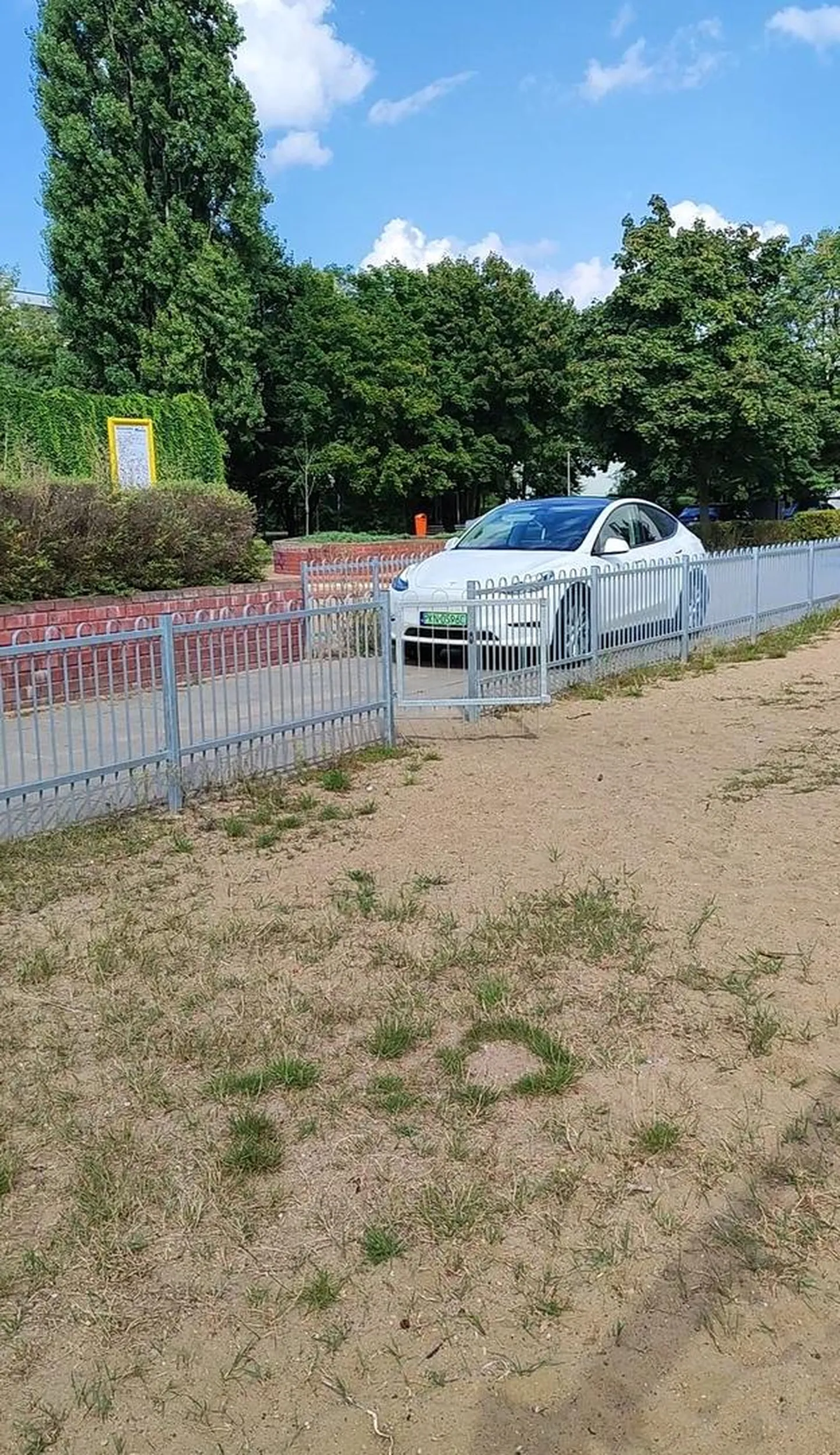 Chłop jedzie wzdłuż po chodniku między dwoma placami zabaw dla dzieci