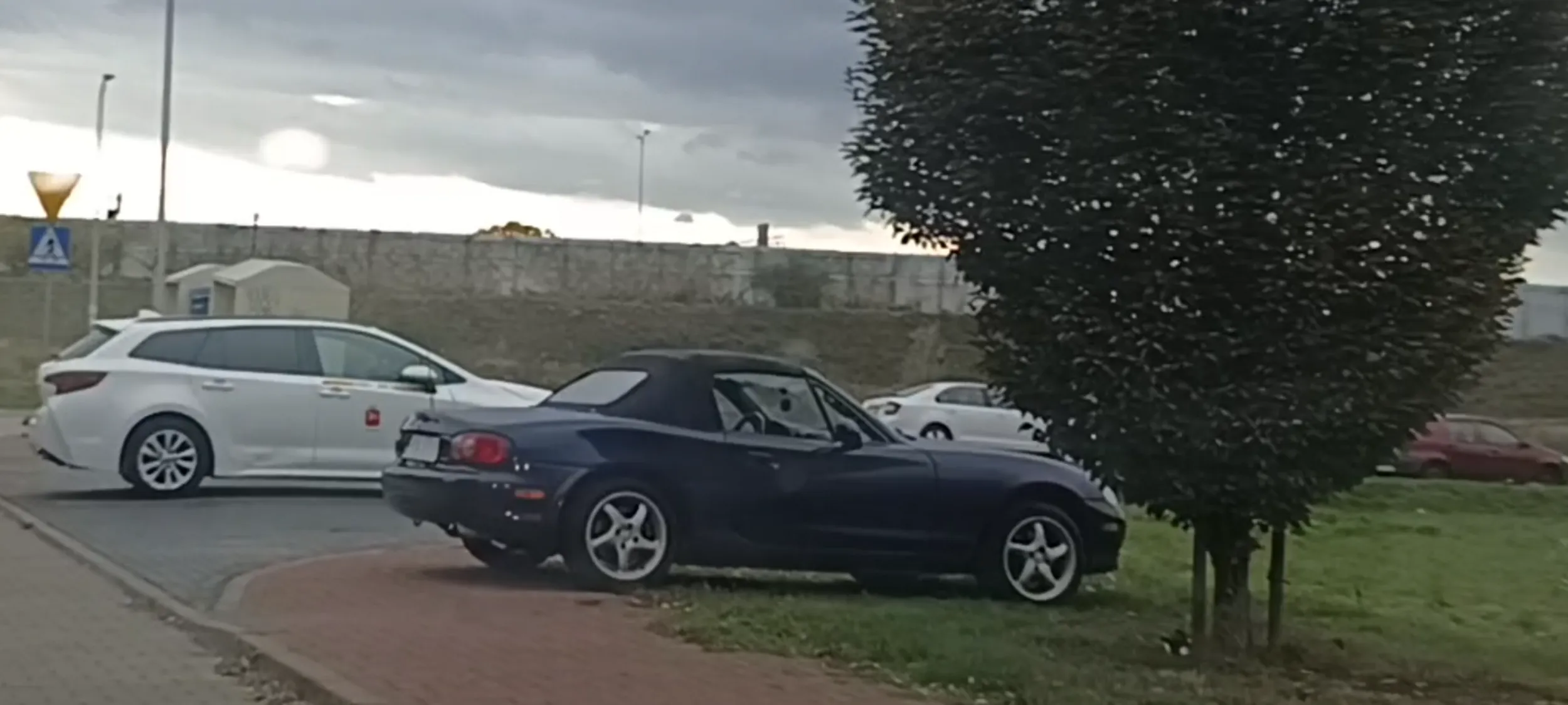 Wrak stoi porzucony na trawniku.