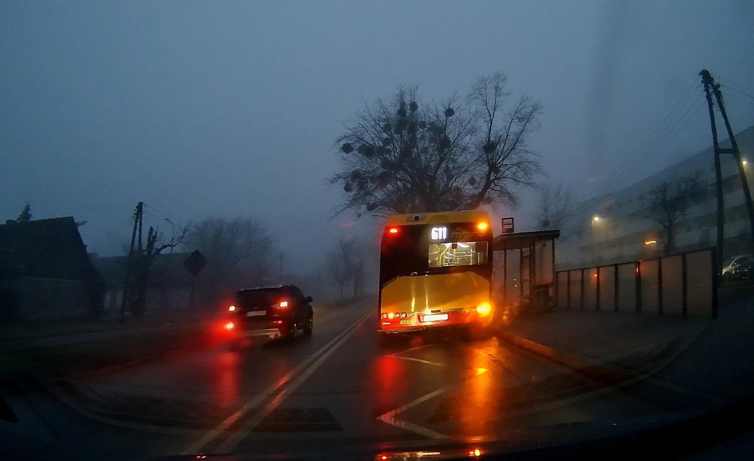 Poznań. Mitsubishi wymija na podwójnej ciągłej autobus na przystanku.