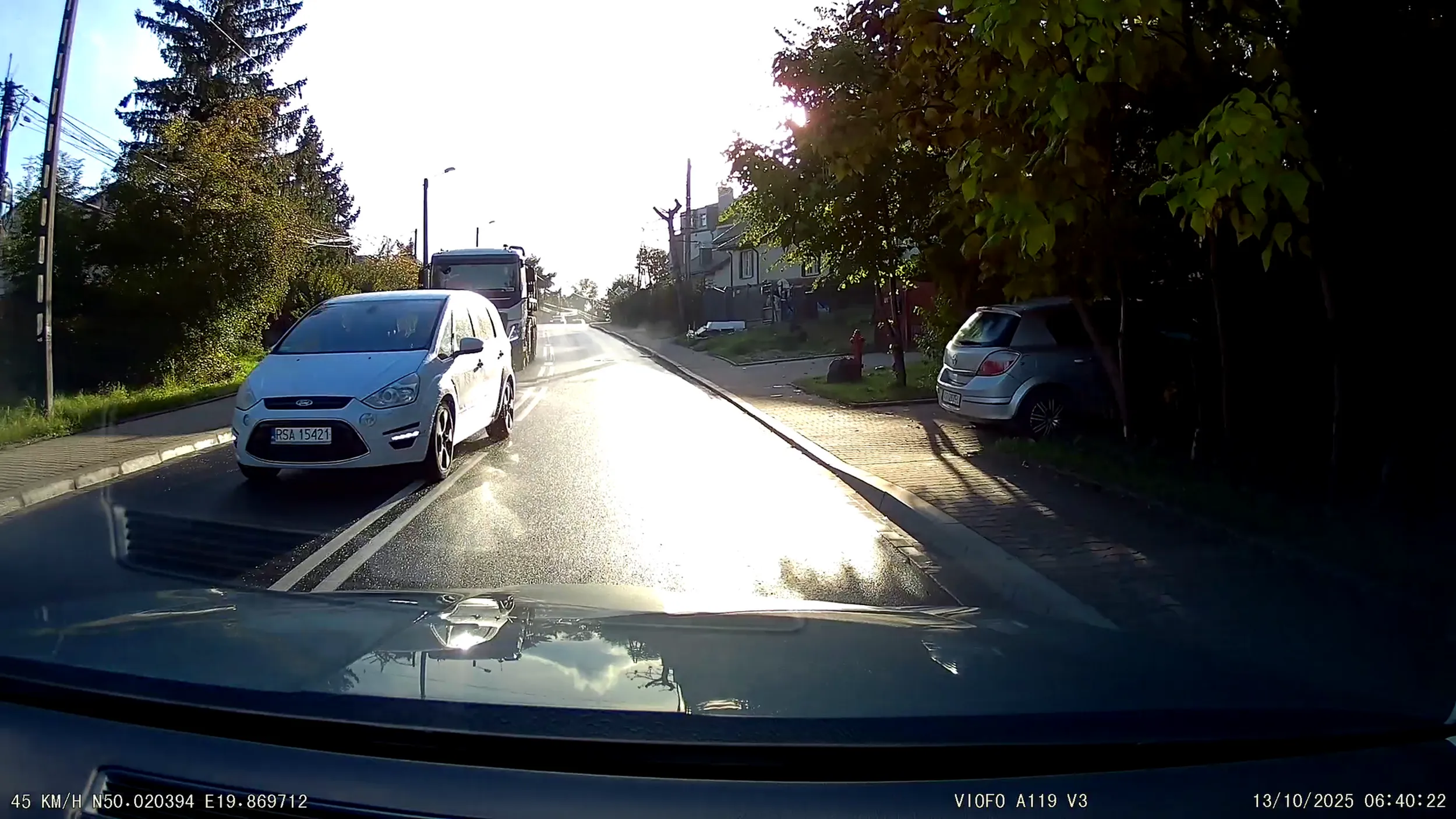 Tuż za wzniesieniem, na podwójnej ciągłej wyprzedza samochód ciężarowy zmuszając kierujących z przeciwnego pasa do hamowania.