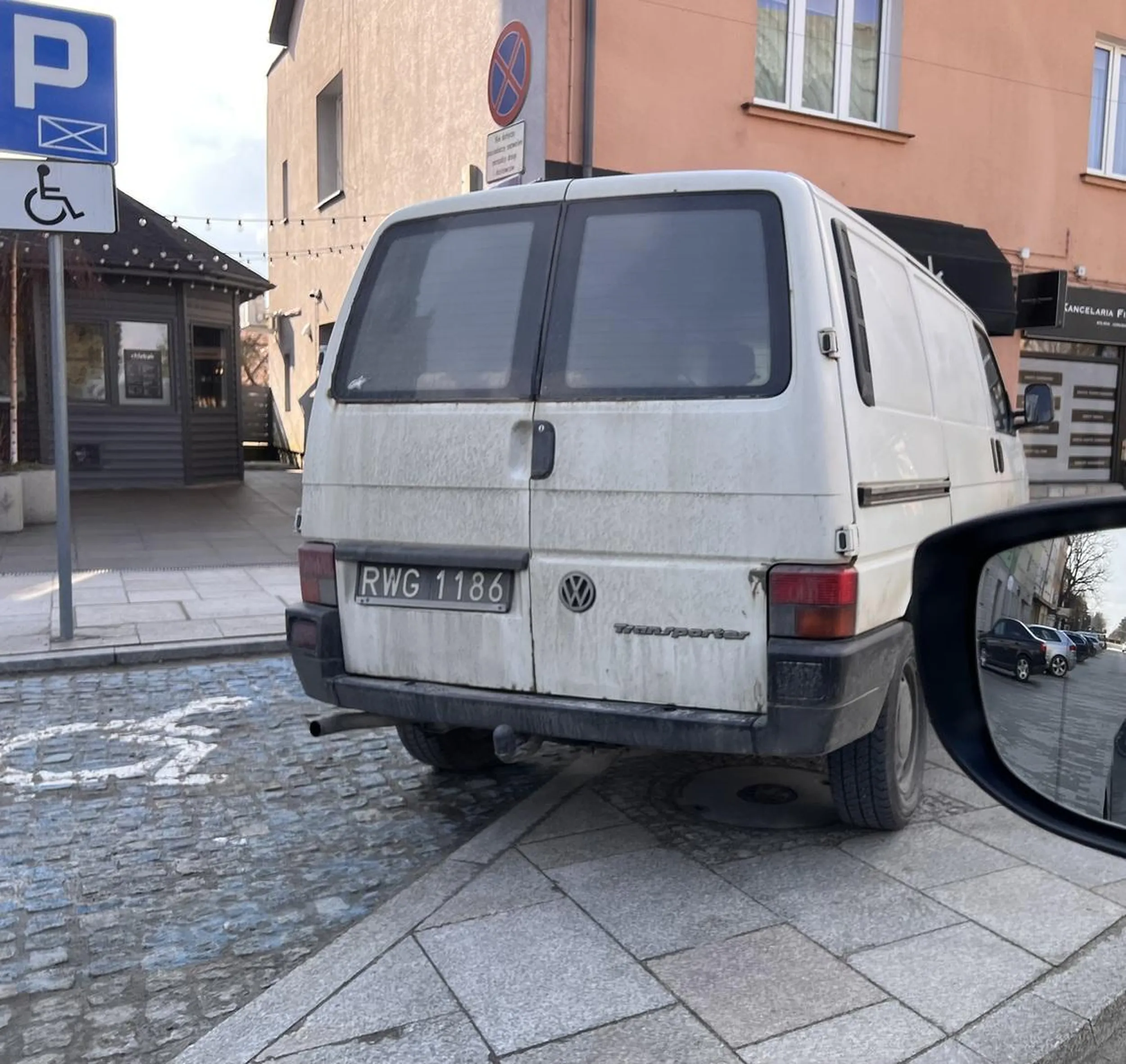Cały parking wolny, więc zaparkował na chodniku i kawałku miejsca dla niepełnosprawnych.