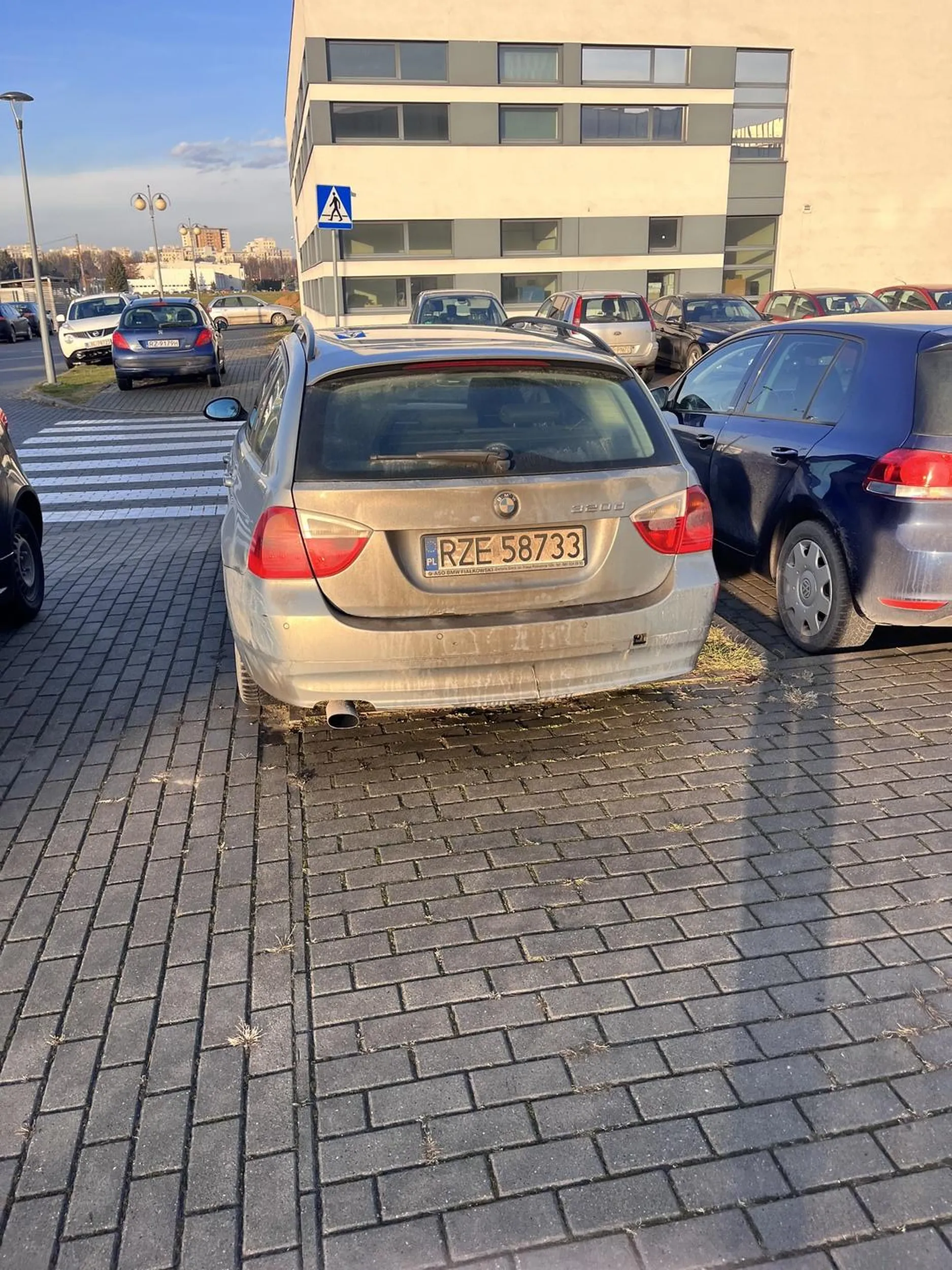 Kierowca tego pojazdu zaparkował w sposób niezgodny z zasadami, częściowo na chodniku i na pasie zieleni, co blokuje przestrzeń przeznaczoną dla pieszych. Dodatkowo samochód znajduje się tuż przy przejściu dla pieszych, co ogranicza widoczność i stwarza zagrożenie dla bezpieczeństwa pieszych. Tego typu parkowanie jest naruszeniem przepisów ruchu drogowego, które zabraniają zatrzymywania się w odległości mniejszej niż 10 metrów od przejścia dla pieszych.