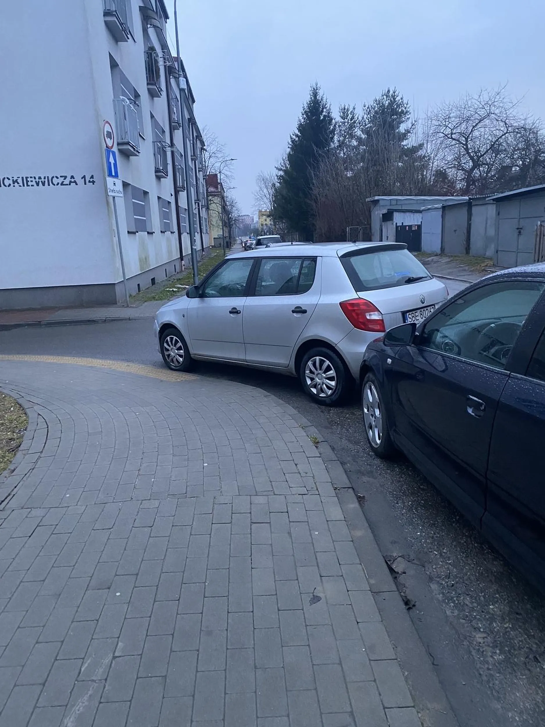 Dobrze zaparkowane auto na zakręcie. Żeby przejść na drugą stronę trzeba obejść i żeby skręcić w lewo trzeba brać taki zakręt, że trzeba wjechać na krawężnik.