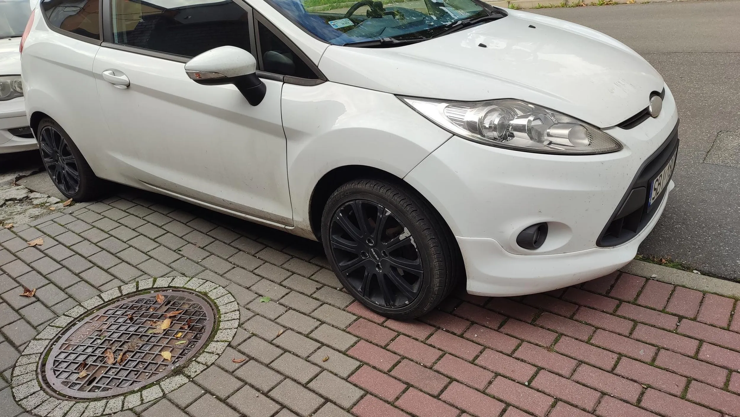 Właściciel "na chama" wciska się na chodnik i nie dosć że blokuje samochód z tyłu, to skutecznie utrudnia wyjazd z ciasnej uliczki. (Stał około 6 godzin.)