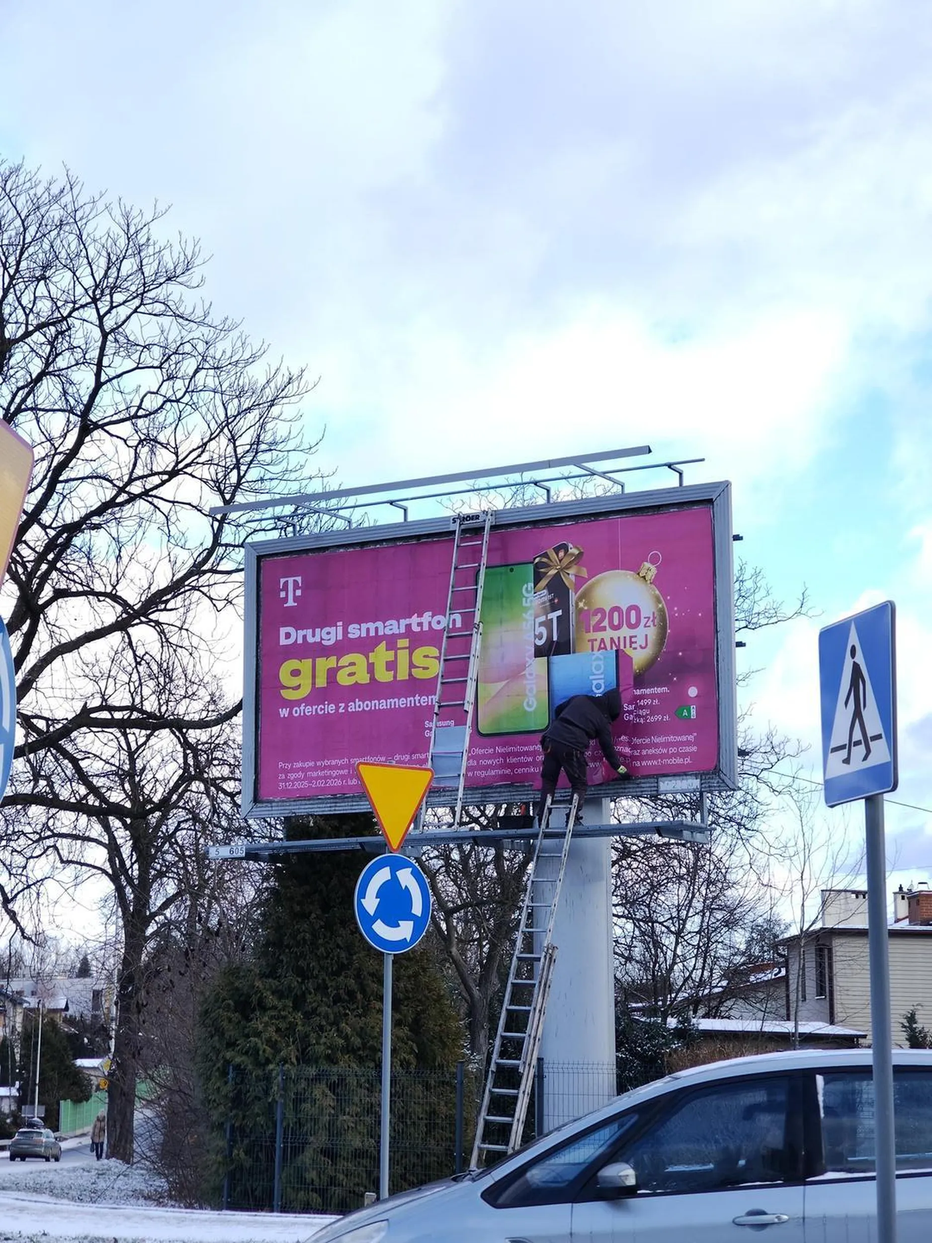 Pewnie, niech ludzie się przeciskają, bo on wykleja billboard.