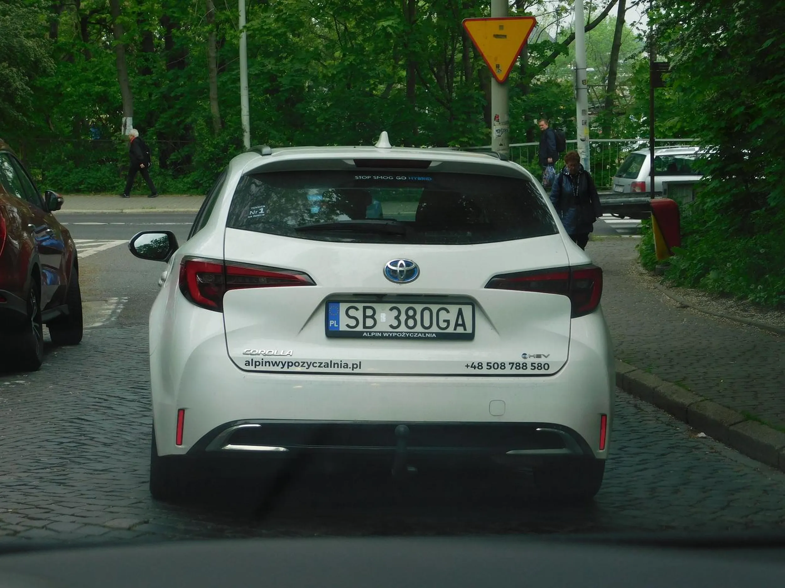 Śmieciarz, wyrzuca pety przez okno.