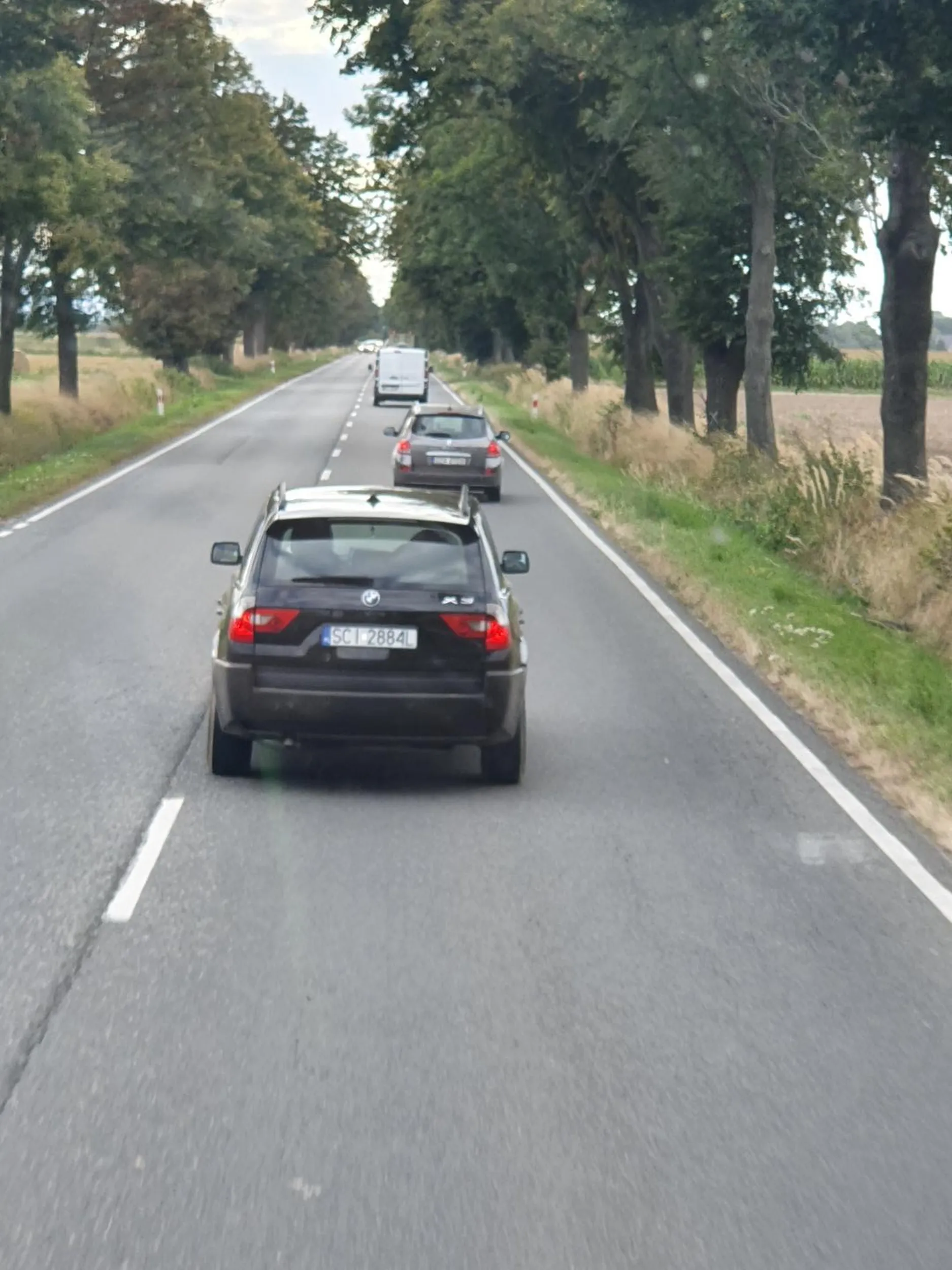 Stary chłop w brelach przyspieszajacy  będąc wyprzedzanym w dodatku jechał z dzieckiem