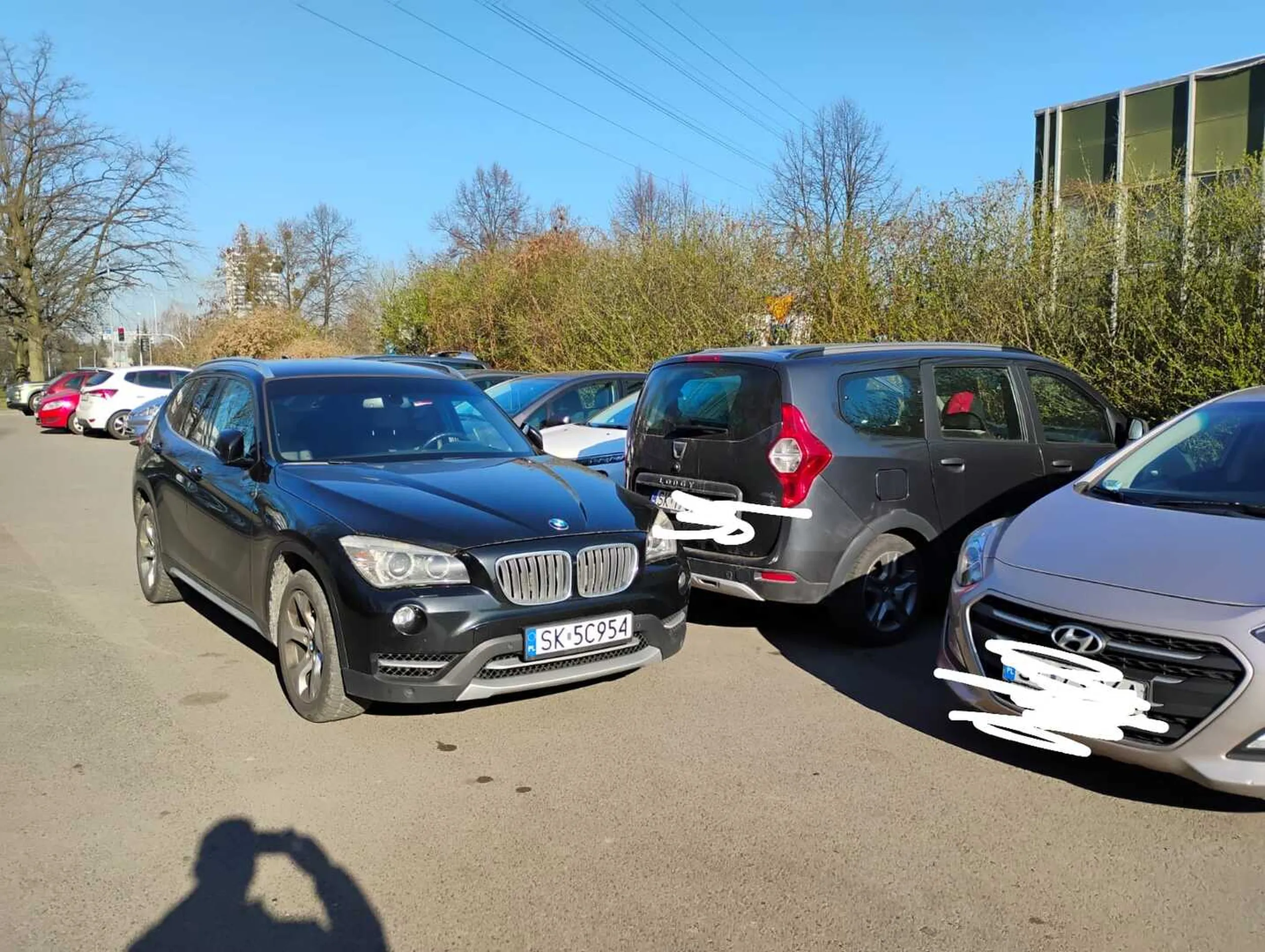 Pan z czarnego BMW blokuje auta pod urzędem komunikacji i idzie rejestrować swój pojazd