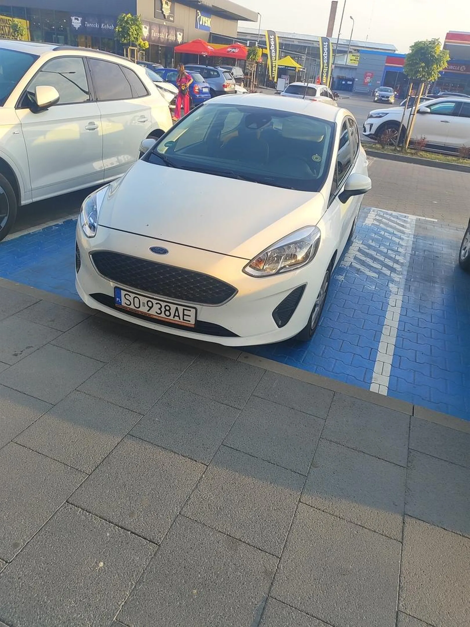 Kobieta w średnim wieku raczej 50+ parkuje na miejscu dla niepełnosprawnych bez posiadania karty, będąc sprawna w 100%, bo gdy powiedziałem jej że policja za chwilę tu będzie biegiem poleciała do Lidla