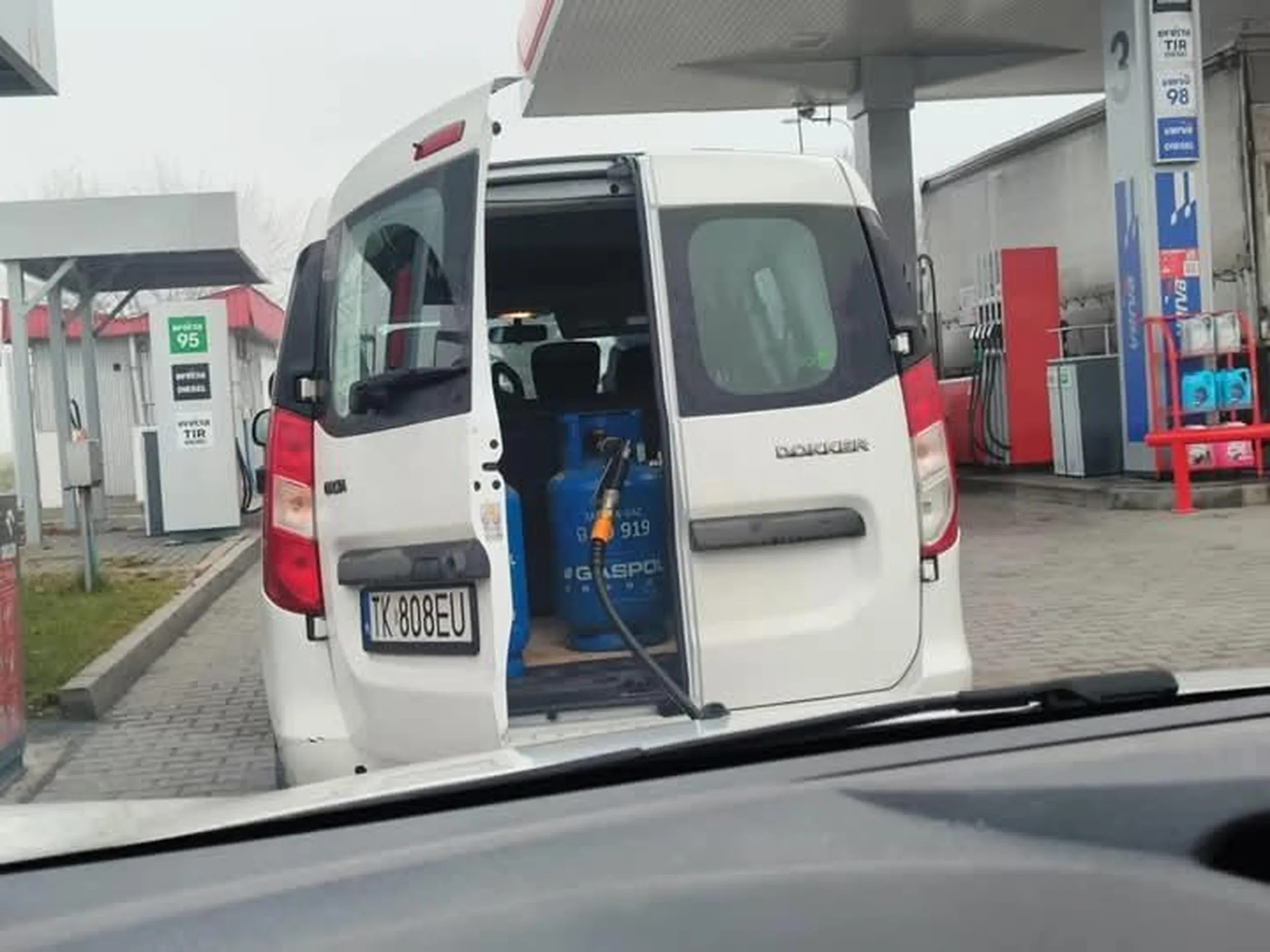 Zjeb tankuje butle LPG.