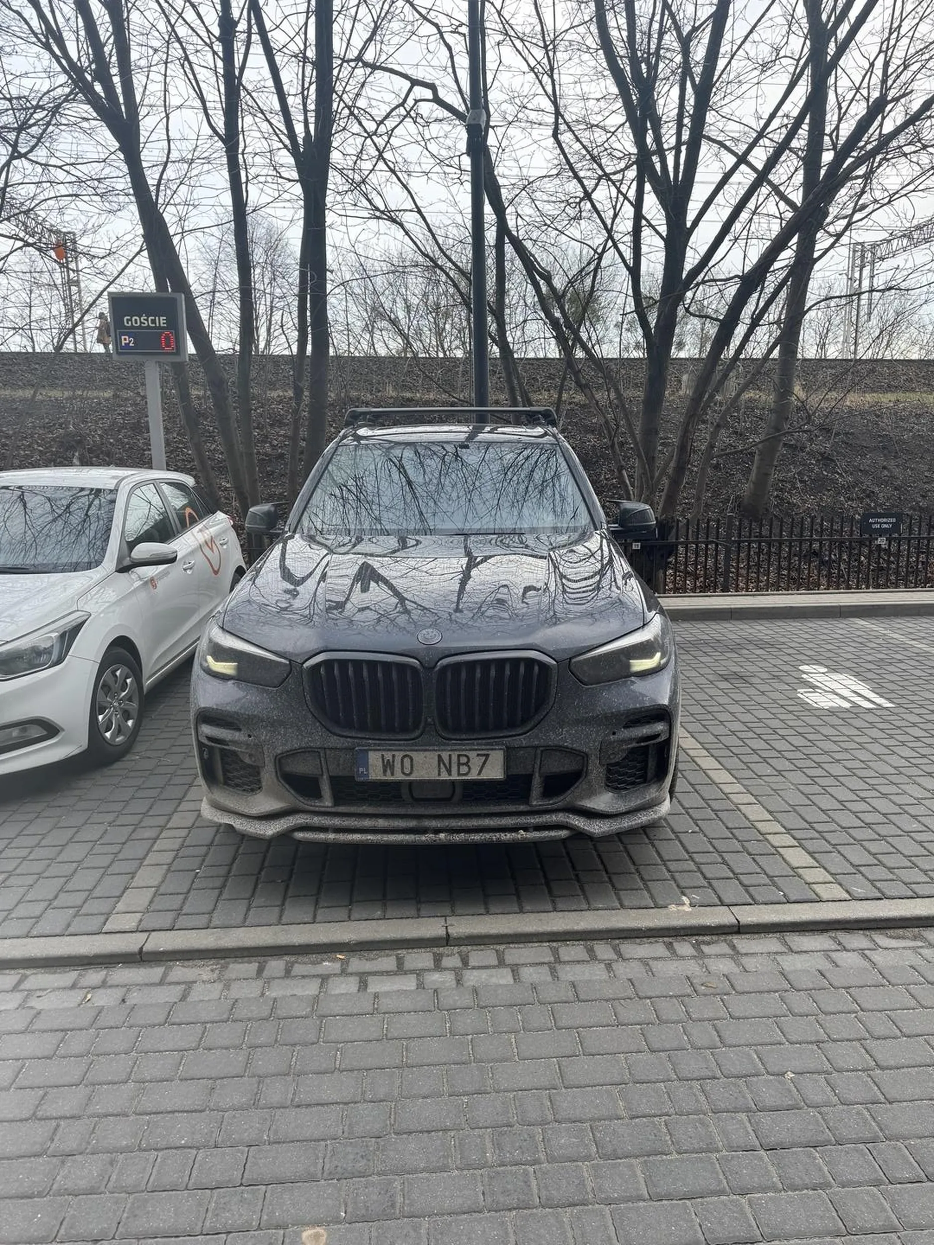 Gość zaparkował na miejscu wymagającym autoryzacji, które było wyraźnie oznaczone tabliczką informacyjną oraz specjalnie zabezpieczone pachołkiem. Mimo to, ów osobnik z pełną bezczelnością, usuwając pachołek, zaparkował na tym miejscu. W końcu przyjechał JAŚNIE PAN swoim BMW więc on nie będzie szukał specjalnie miejsca parkingowego. Stał tak ok. godzinę i przez cały ten czas miał włączone światła oraz otwartą szybę, więc można domniemywać, że inteligencja tego osobnika nie jest na zbyt wysokim poziomie... no cóż, wybaczmy mu. Nie każdy musi być geniuszem.