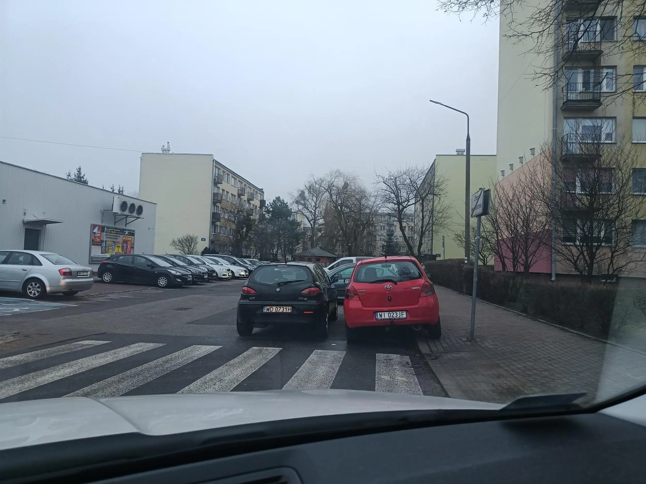 2 przygłupy zaparkowały jak przygłupy przed przejściem i w przejeździe w sposób umożliwiający wjazd śmieciarce do śmietnika.