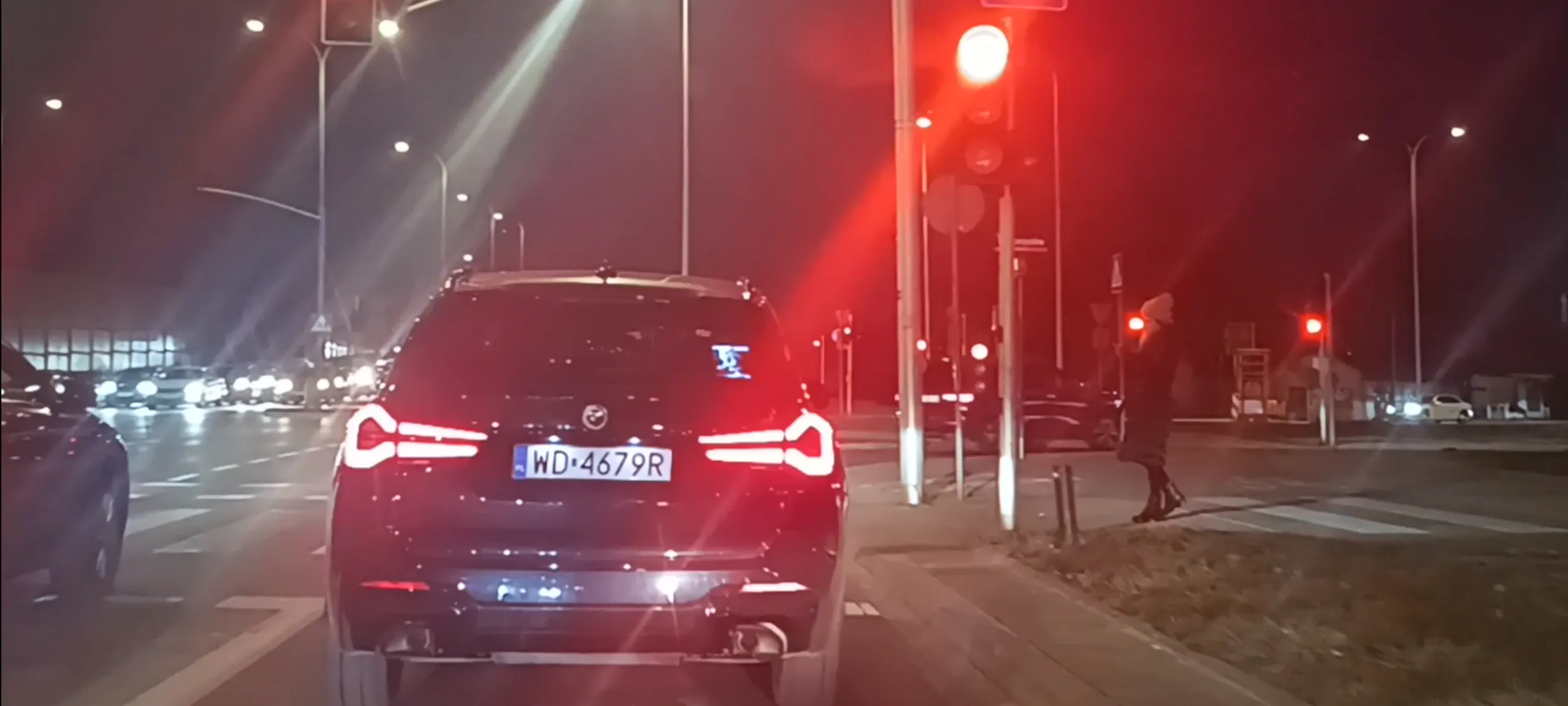 Bandyta drogowy przejeżdża przez  skrzyżowanie na czerwonym sygnalizatorze świetlnym.