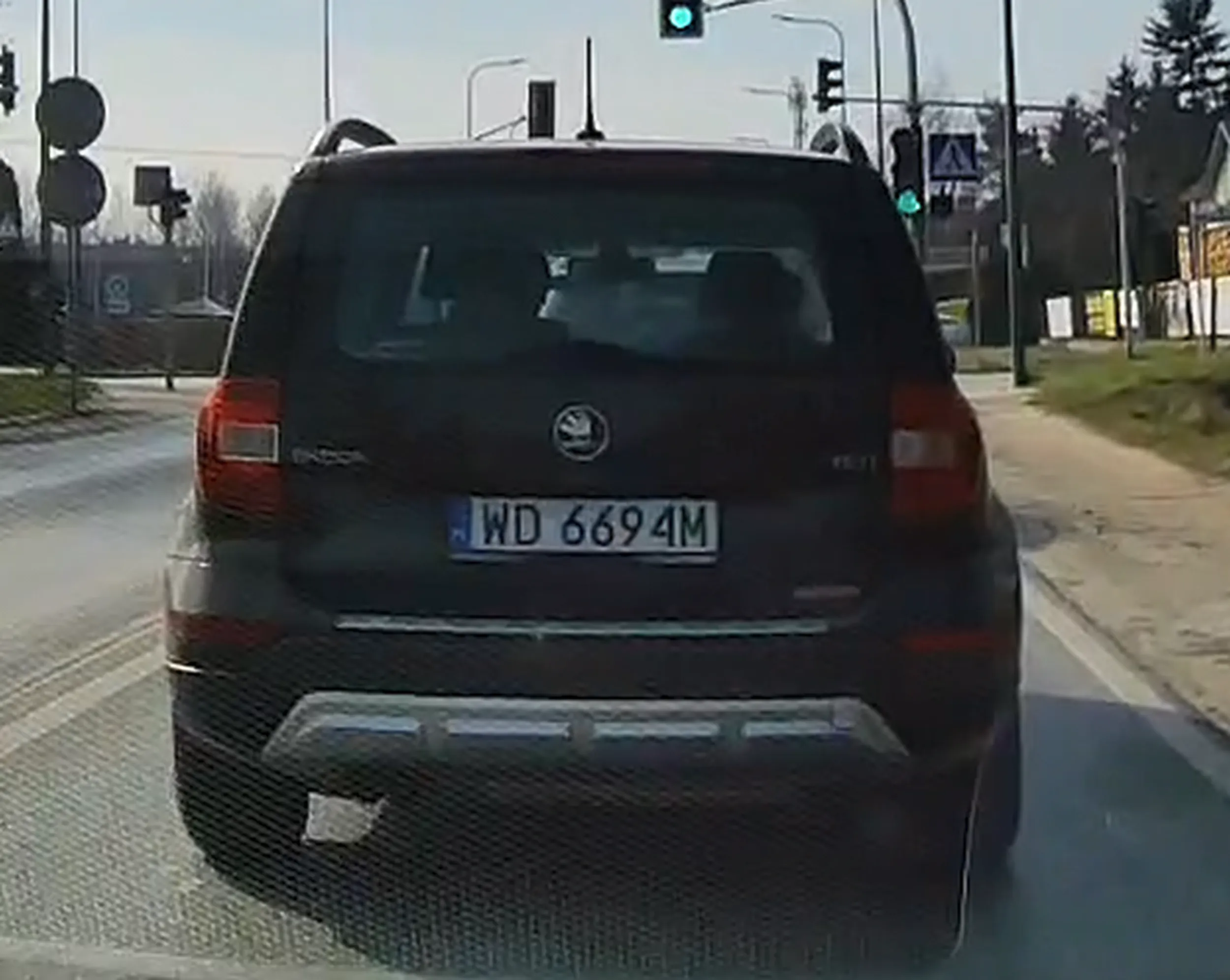 Śmieciarz wyrzuca kubek przez szyberdach.